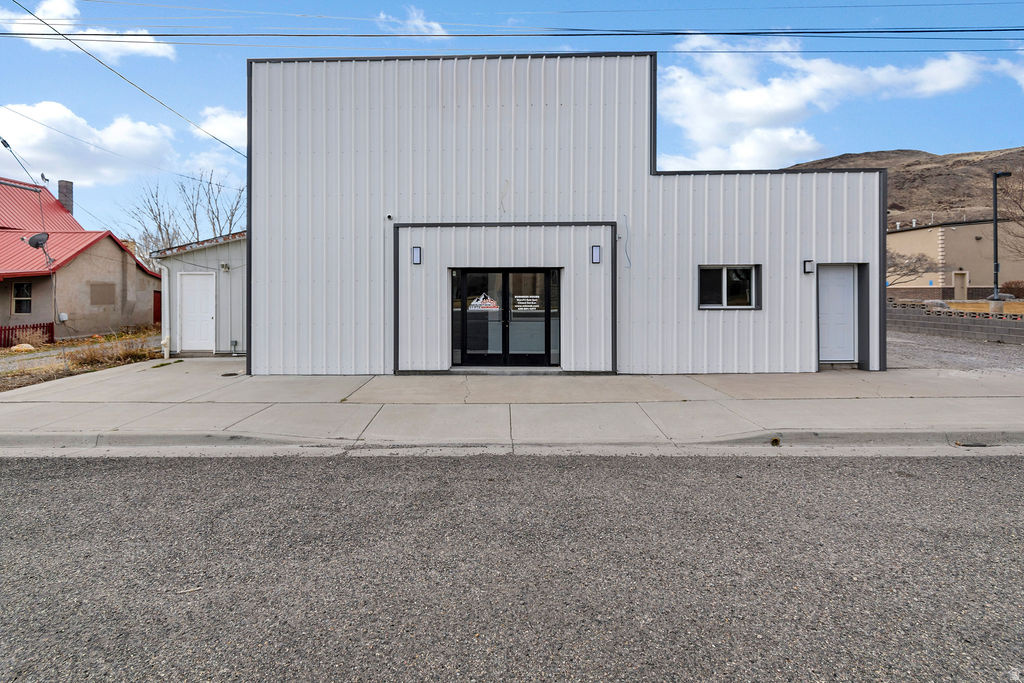 Fully Remodeled Interconnected Commercial Facility  I-70 Corridor Strategically located minutes from I-70 with strong regional access, this extensively remodeled commercial complex offers 9,823 square feet on 0.43 acres. The layout is fully interconnected, allowing efficient flow between showroom, administrative offices, and multi-bay shop facilities-ideal for operational continuity and team collaboration. The east building serves as the primary public-facing entrance, featuring double-door access into a professional reception area and contractor service desk. The space includes an expansive showroom, private conference room, and full kitchen. Interior finishes reflect recent modernization, including custom millwork, upgraded cabinetry, epoxy flooring, LED lighting, and clean, contemporary detailing. The private office wing consists of five individual offices, dedicated restrooms, and a staff break area-well suited for executive operations, sales teams, or administrative functions requiring both privacy and accessibility. The east-to-west linear shop is designed for operational efficiency, offering four overhead doors and multiple work zones to support production, storage, or service-based activities. The west shop building expands functionality with two additional overhead doors, gas-forced air heat, lift capacity, a shop restroom, and two large attached flex rooms appropriate for office, fabrication, or specialized workspace. Above the west building, a newly finished loft area provides additional flexible square footage, including one large common area and multiple smaller private rooms. This space is adaptable for training, design work, administrative overflow, or expanded operational needs.  Capital improvements are substantial and include:          New roof and exterior sheeting         Complete electrical rewire with updated service panel         Updated plumbing         High-efficiency insulation         LED lighting throughout         Brand-new septic system         Epoxy-finished shop floors         New carpet in office areas         Integrated security system  This is a turnkey commercial asset offering visibility, infrastructure, and operational versatility within the I-70 corridor. Suitable for contractors, light industrial users, service-based businesses, or investors seeking a well-improved and functionally cohesive commercial holding.