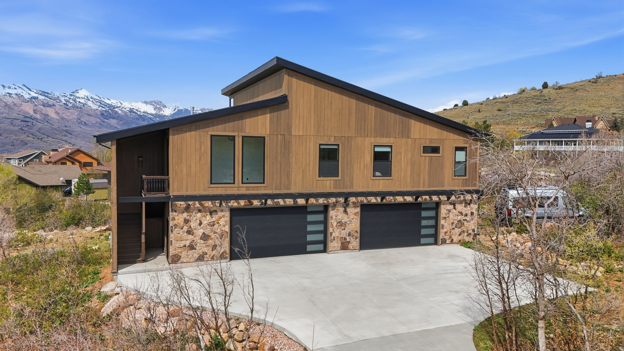 The garage alone is worth the drive up. A heated 53' x 32' toy barn with 10-ft ceilings, 9-ft doors, epoxy floors, and RV electrical hookup, built to hold everything you own and then some. Skis, sleds, side-by-sides, a boat - there's room for all of it and a full shop setup to match. Then step outside: you're sitting on a creekside half-acre with mature scrub oak, panoramic mountain and valley views, and zero lawn to babysit. Powder Mountain is 8 minutes away. The trails, the elk, and the river aren't much farther. Built in 2024 with engineered construction, foam insulation, and sound-dampened walls, this place is as solid as the mountain it sits on. Upper-level living opens up to 10- to 20-ft ceilings with exposed I-beams, a great room that earns the name, and a kitchen built to feed a crowd after a big day out. Two bedrooms done right with no wasted rooms, no wasted square footage, just the space you actually want. The dedicated office keeps work separate when it matters. Come home to a hot tub, cold plunge, covered deck with a gas firepit, and Sonos sound inside and out. Fully furnished and completely turnkey - show up, unload the truck, and start living. This is a base camp, not a compromise.