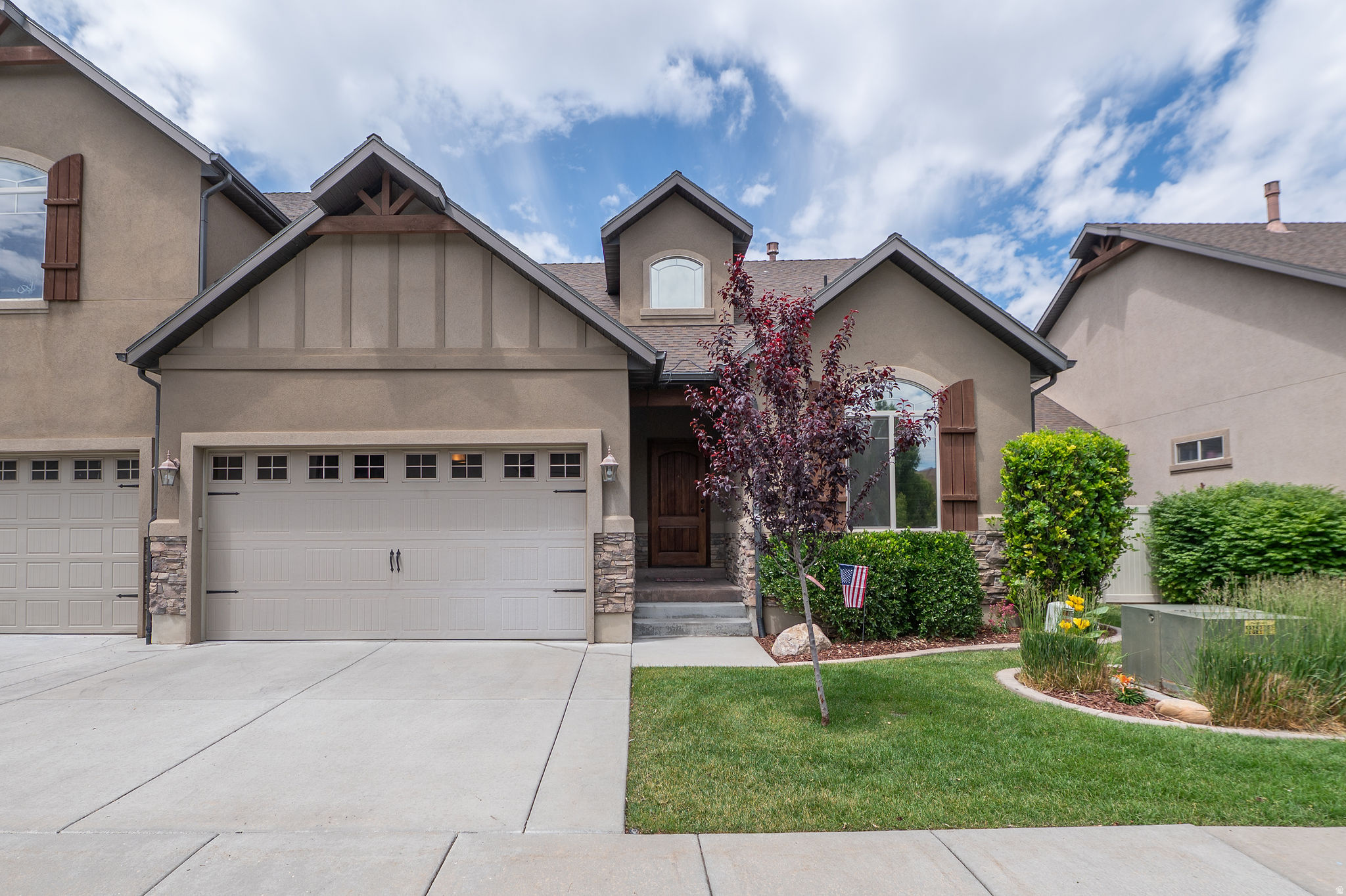 Welcome home to resort-style living in one of Northern Utah's most desirable communities. This beautiful craftsman-style townhome offers timeless curb appeal with stacked stone accents, a warm wood front door, manicured landscaping, and a setting that feels special from the moment you arrive. Inside, you'll love the soaring entry, rich hardwood floors, vaulted ceilings, arched doorways, and an impressive great room filled with natural light. The floor-to-ceiling stacked stone fireplace and custom knotty alder built-ins create a warm, inviting space perfect for relaxing or entertaining. The open-concept kitchen features knotty alder cabinetry, granite countertops, a bold black granite island with bar seating, stainless appliances, hardwood floors, and a charming etched glass pantry door. The easy flow between the kitchen, dining, and living areas makes everyday life feel effortless. The primary suite is a true retreat with vaulted ceilings, plush carpet, a spacious walk-in closet, and a spa-inspired bathroom with granite counters, a tiled walk-in shower, soaking tub, and beautiful finishes. Additional bedrooms offer a comfortable space for guests, family, or a home office. Enjoy evenings on the covered patio overlooking a private, manicured yard with vinyl fencing and low-maintenance landscaping. The drywalled 2-car garage provides plenty of room for vehicles, storage, and all the extras. The community amenities are the cherry on top: clubhouse, fitness center, catering kitchen, resort-style pool, hot tub, mature trees, maintained common areas, and gorgeous mountain views. Beautiful home. Incredible community. Northern Utah living at its finest!