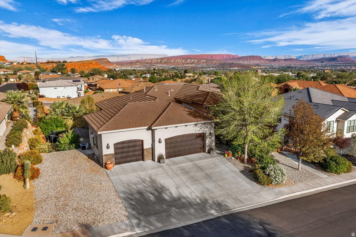 A rare find under $1M with a dedicated cinema, mountain and valley views from the covered deck, oversized 3-car garage, and 4,500 sq ft nestled in a quiet cul-de-sac! The cinema boasts raised seating, projector, and 120' screen! You'll love the 10-foot ceilings throughout, garage space for your toys and hobbies, hardwood floors, quartz and granite countertops, custom cabinetry and tile work, and walls of oversized windows that fill the home with natural light and showcase the views. At $200/sq ft, this is one of the best values in the St. George market! The outdoor space is just as impressive, and the large covered deck extends the living space year-round. This property offers both luxury and functionality! Plantation shutters. Six bedrooms across two levels. Walk-out daylight basement. Whole-house water filtration. Established shade trees. Cul-de-sac privacy. Layout designed for gathering and entertaining. Professional landscaping. Fire pit. Security system. Immaculate home. Convenient location.