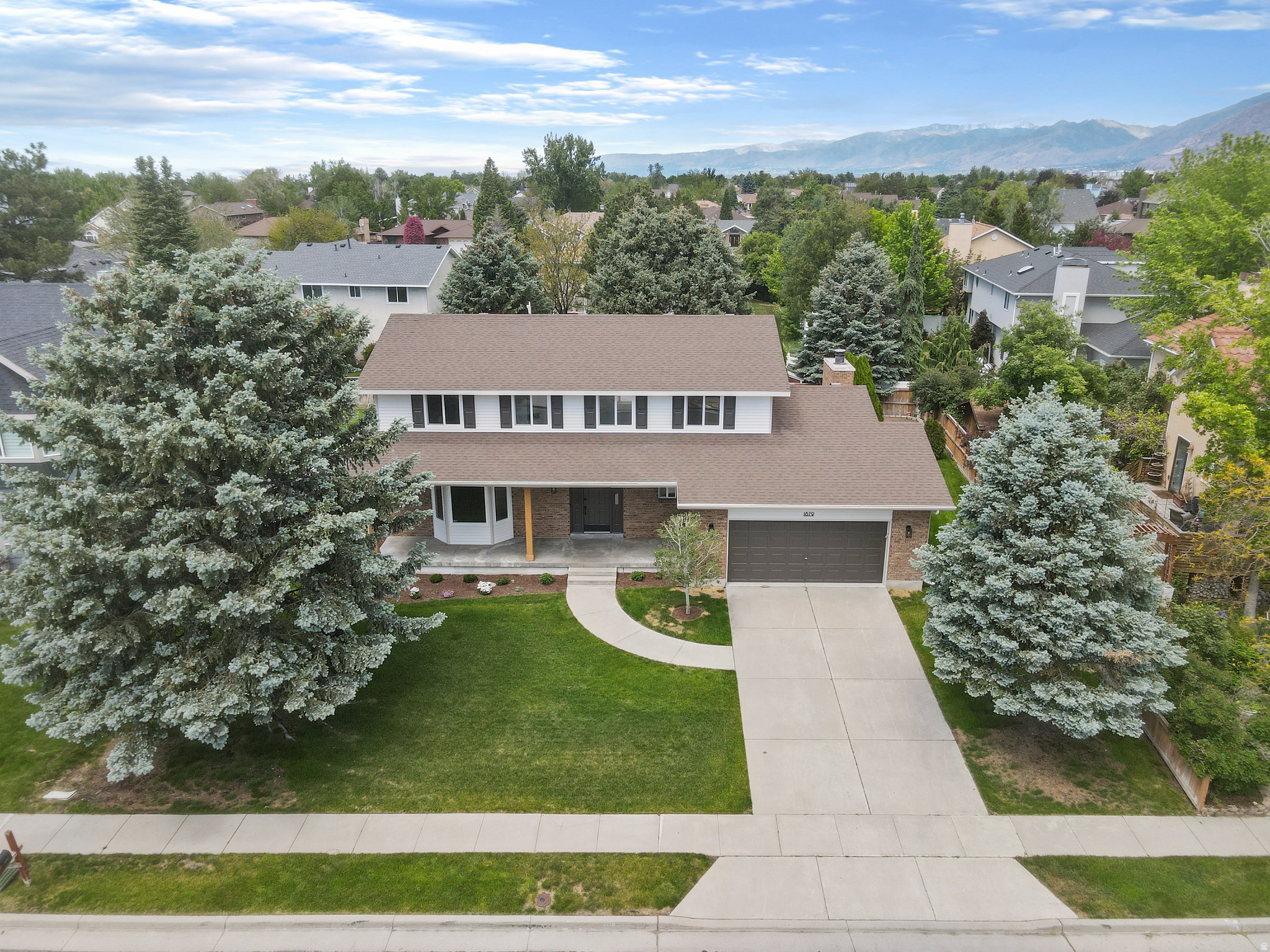 Absolutely stunning, fully remodeled home located in a highly desired, quiet neighborhood with beautiful mountain views. Cared for by the original owner and thoughtfully updated from top to bottom, every inch of this home has been finished with quality, style, and attention to detail. It truly feels like a brand-new home.  The main floor features a large open-concept layout with generous living, dining, and family room spaces, a beautiful gas fireplace, all-new windows, stainless steel appliances, a double oven, and a convenient half bathroom. The fully finished garage includes epoxy floors, and the mudroom with a sink adds everyday functionality.  Upstairs, the spacious primary suite is a true retreat, featuring an extremely large walk-in closet that was previously a full bedroom. The gorgeous primary bathroom includes a stand-alone soaking tub, full shower, and its own private laundry area. Two additional bedrooms and a full bathroom complete the upper level.  The basement offers even more flexible living space with two additional bedrooms, a gorgeous three-quarter bathroom, a large downstairs room with a full kitchenette, a finished storage room, and a fully finished utility room featuring a high-efficiency furnace and tankless water heater. There is also a downstairs laundry room with washer and dryer included.  The backyard is just as impressive, offering a covered patio, garden area, mature trees, and an extremely private setting that is hard to find. From the gorgeous outdoor space to the quiet neighborhood and mountain views, this home checks every box.  With a complete remodel, thoughtful layout, beautiful finishes, and an incredible location, this is a rare opportunity to own a truly move-in-ready home in one of the area's most sought-after neighborhoods.    Square footage figures are provided as a courtesy estimate only and were obtained from county records.  Buyer is advised to obtain an independent measurement.