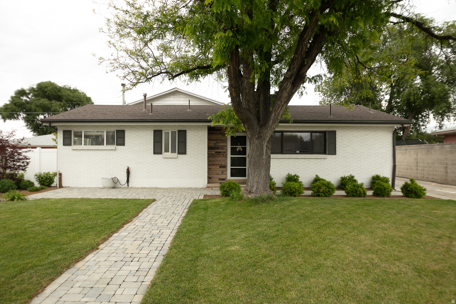 Multiple Offers Received, offers being reviewed Tuesday at 7:30pm. Beautifully updated Murray rambler featuring a very spacious primary suite, fully functional mother-in-law apartment, oversized detached garage/workshop, and an incredible private backyard setting rarely found in the area. Situated on a beautifully landscaped .28 acre lot, this home combines functionality, flexibility, and lifestyle appeal in one of Murray's most convenient locations. The spacious floor plan offers 4 bedrooms, 3 bathrooms, and multiple living spaces ideal for multi-generational living, rental income opportunities, or a private guest setup. The lower level includes a separate entrance, second kitchen, and fully functional mother-in-law apartment, an increasingly desirable feature for today's buyers. The oversized detached garage/shop is a standout feature with ample room for vehicles, storage, hobbies, workshop space, recreational toys, or additional parking flexibility. Buyers looking for usable garage and workshop space will immediately appreciate the versatility this property offers. Inside, the home has been thoughtfully updated with improvements including flooring, fixtures, lighting, cabinetry, countertops, updated electrical/GFCI outlets, and additional system upgrades over time. A newer roof has also been installed on the main house within the last five years. The exterior setting is truly special. The professionally landscaped front and backyard create incredible curb appeal and a peaceful outdoor environment with mature landscaping, entertaining spaces, a beautiful deck, and a large grassy yard perfect for relaxing, entertaining, pets, or play. One of the most unique features of the property is the private gated access to the neighborhood park directly behind the home, accessible by only a small number of neighboring properties. Enjoy direct access to green space, basketball courts, playground areas, and picnic amenities without HOA restrictions. Conveniently located near Murray High School, shopping, Costco, IMC Hospital, freeway access, parks, dining, and commuter routes, this home offers a rare combination of lot size, functionality, outdoor living, detached garage utility, and mother-in-law flexibility in the heart of Murray. Square footage figures are provided as a courtesy estimate only. Buyer is advised to obtain an independent measurement.