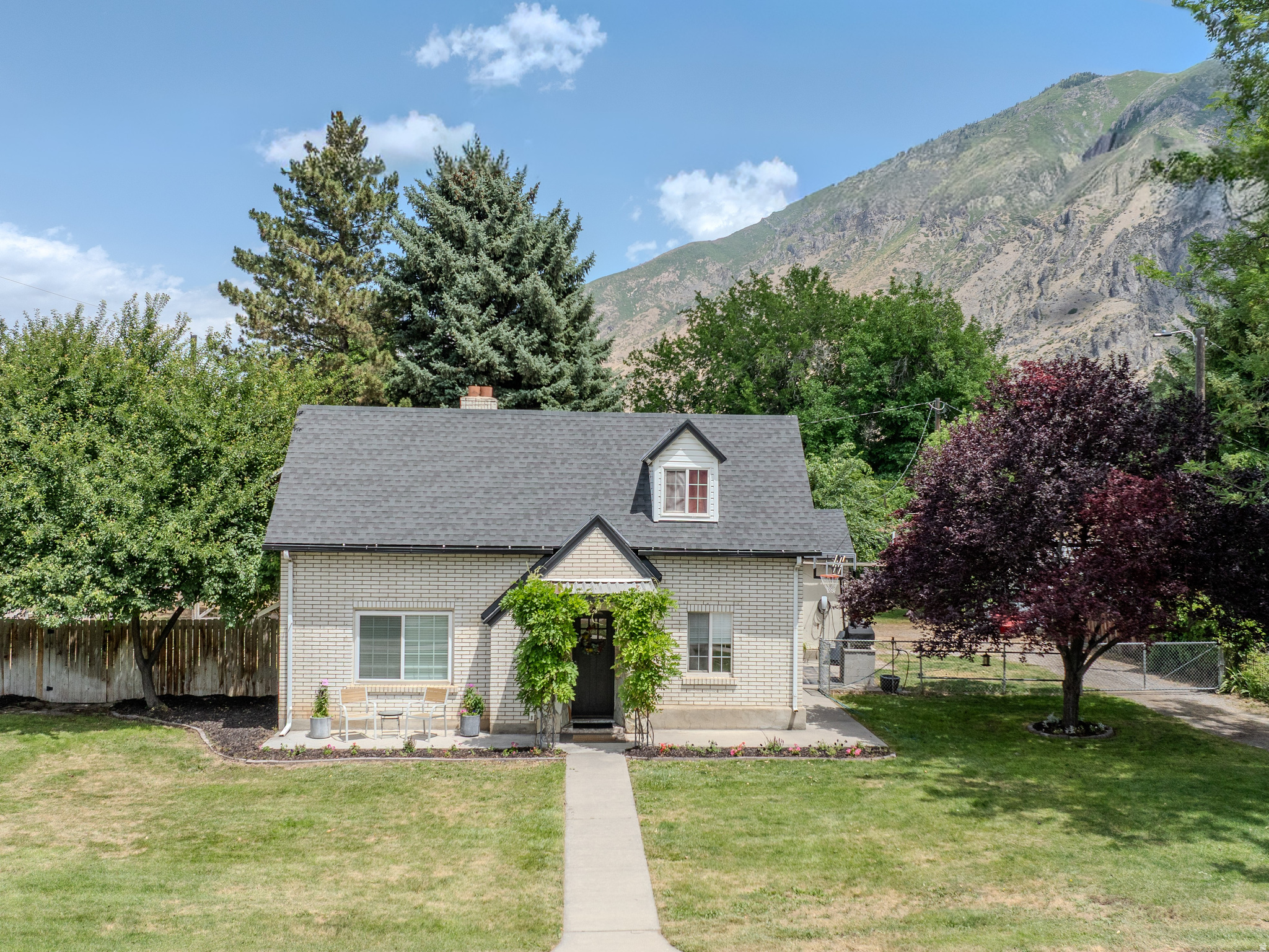 RARE FIND! Located in Springville's historic area, this home sits on a .49-acre lot with a carriage house, cottage, in-between space, and shed. The main home's interior has been thoughtfully updated with built-in storage throughout, featuring a new roof and carpet in 2025 and new main-level flooring in 2024. The front door is framed with blooming lavender Wisteria. The front quarter-acre and back garden have pressurized irrigation, while the back quarter-acre has flood irrigation available through Springville City. The fully fenced backyard includes a trampoline, basketball hoop, playset, fire pit, and pizza oven, plus an electric car charger. The basement offers a storage room and laundry room, with washer and dryer included. This property includes three parcel numbers: 06:060:0001, 06:050:0020, and 06:050:0022. Square footage figures are provided as a courtesy estimate only and were obtained from Utah County Records Online; buyer is advised to obtain an independent measurement.