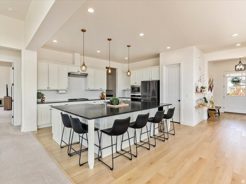 This white modern farmhouse blends classic charm with upscale contemporary living across expansive 5,826 square feet. Designed with both comfort and entertaining in mind, the home features 6 spacious bedrooms and 4.5 baths. Inside, the open concept floor plan creates a seamless flow between the main living area. A large, light-filled kitchen serves as the heart of the home, complete with an oversized island that offers generous seating. The kitchen opens directly into the family room, making it perfect for gatherings, whether casual or formal. Stainless steel appliances, abundant cabinetry, 2 pantries, and thoughtful upgrades throughout to elevate the space, combining functionality with a polished modern feel. Step outside to a large deck that overlooks a spacious backyard with a beautiful covered pavilion, ideal for hosting, relaxing, or enjoying outdoor living, with plenty of room for entertaining both indoors and out. This home is designed to accommodate a vibrant lifestyle while maintaining the warmth and simplicity of a modern farmhouse.