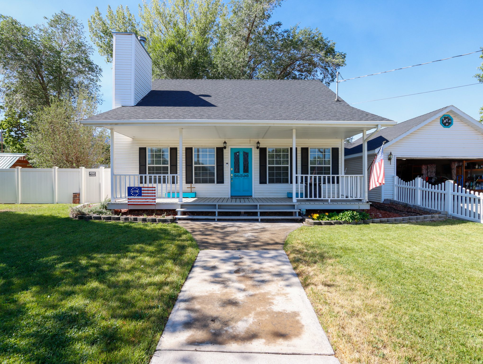 Charming bungalow-style cottage on a spacious double lot in a peaceful neighborhood. This home is surrounded by mature shade trees and fruit trees. Around the home, there's plenty of room for RVs, trailers, vehicles, gardening, animals, or future projects. Properties like this are hard to find! Relax on the large covered front porch or enclosed patio while taking in the quiet surroundings. Inside, the efficient floor plan offers surprisingly spacious bedrooms, hardwood floors, a functional galley kitchen, excellent storage, and an attached two-car garage. Friendly neighbors, nearby schools, and the middle school track just up the street make this an enjoyable place to call home. Whether you're looking for room to grow, space to pursue your hobbies, or simply a peaceful small-town lifestyle, this well-maintained property offers exceptional opportunity. *Square footage is provided as a courtesy estimate only. Buyer is advised to obtain an independent measurement.