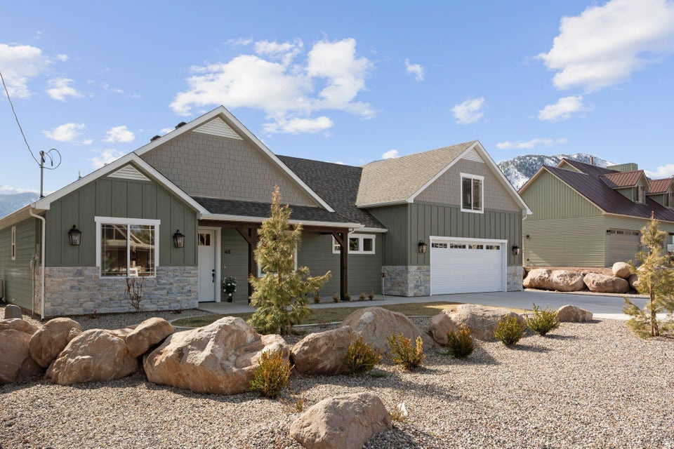 Located in the heart of Pine Valley, this brand-new custom home offers a rare opportunity to own a thoughtfully designed property that has never been lived in. Situated on a spacious .43-acre lot along a paved road, the home captures stunning views, including Gardner Peak, and is built for both comfort and elevated mountain living. This 4-bedroom, 3.5-bathroom home features a highly functional layout with quality craftsmanship throughout. As you arrive, you're welcomed by a charming front porch accented with custom mountain beams. Inside, the home showcases beautiful oak LVP flooring, white custom cabinetry, and a warm, inviting fireplace. The main living area boasts vaulted ceilings, seamlessly connecting the living room and kitchen for an open, airy feel. The kitchen is designed to impress, featuring a large island, custom appliances, a built-in range hood, and excellent storage. Just off the kitchen is a spacious pantry and prep area--perfect for those who love to cook and entertain. Expansive windows bring in natural light and frame the picturesque backyard and mountain views. The main level includes an office, two additional bedrooms, and a full bathroom, all positioned for convenience. Privately situated on the opposite side of the home, the primary suite is designed to capture morning sunlight and offers a seamless flow into the oversized closet and connected laundry room. The primary bathroom features double vanities, custom oak cabinetry, a soaking tub, and a beautifully tiled oversized shower, all with bright southern exposure. Upstairs, you'll find an expansive bonus room, an additional bedroom, and a full bathroom--ideal for guests, recreation, or flexible living space. A deep, oversized garage provides ample room for vehicles, storage, and outdoor gear. Built with quality and longevity in mind, this home blends modern finishes with timeless mountain design--ready for its very first owner to enjoy.