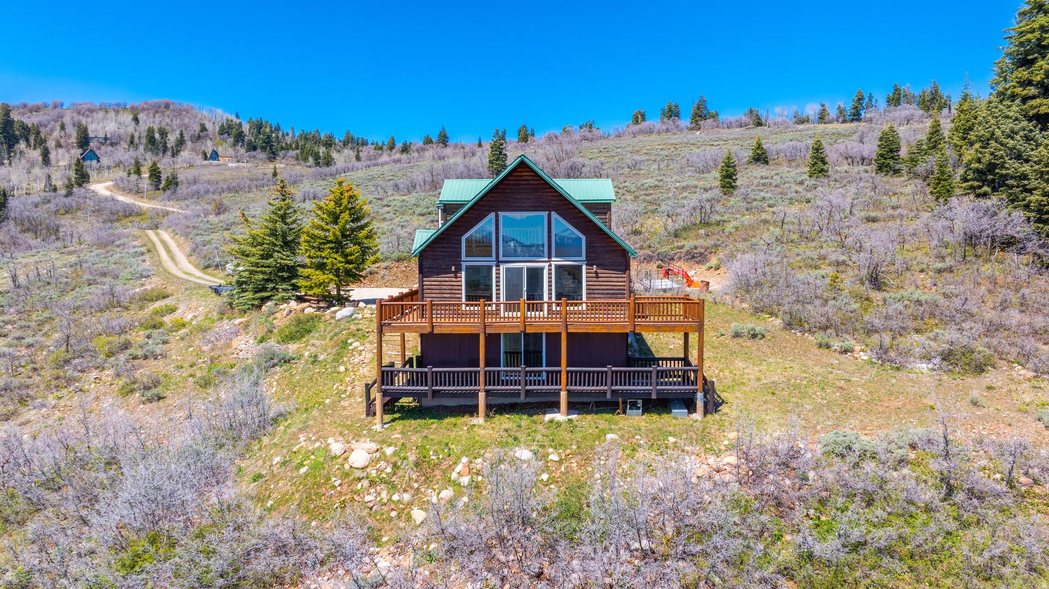 Tucked into the Forest Meadow area of Tollgate Canyon, this private 10acre retreat offers a peaceful escape from the rush of everyday life.  Inside, the open floor plan features an updated kitchen that flows into a spacious living room with vaulted ceilings and a cozy fireplace. Oversized windows frame sweeping easterly views of the Uinta Mountains, filling the home with natural light and yearround scenery. A springfed pond sits just off the side of the home, drawing wildlife and creating the perfect backdrop for a fire pit or quiet outdoor gathering space. With one bedroom in the loft, another on the main level, and two additional bedrooms in the lower level, the layout offers flexibility for families, guests, or multiuse living. Home sits on a secondary plow route for year-round living.  The setting is pure mountain serenity, with rolling hills, abundant wildlife, and longrange views that make this property an ideal weekend getaway or a comfortable fulltime residence. Home comes furnished with convenience and luxury for immediate occupancy.  And with Park City Mountain Resort, Deer Valley, and historic Main Street just 30 minutes away, you're never far from worldclass recreation, dining, and amenities. Kubota Tractor, 4 Wheelers & CanAm w low miles w/trax and trailer are available separately.