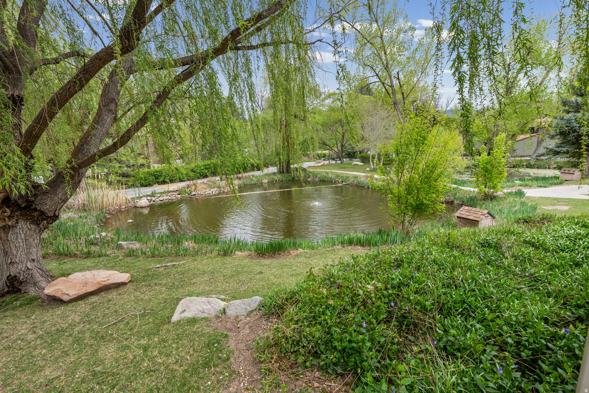 Rare top-floor condo surrounded by mature trees and peaceful ponds - offering a quiet, park-like setting in the heart of Murray. Welcome to one of the best-positioned units in The Willows, where privacy, space, and natural surroundings come together in a way that's hard to find at this price point. Surrounded by lush greenery and tucked within a quiet, well-maintained community, this home offers a rare sense of calm. Just steps away, enjoy peaceful ponds with ducks and geese, walking paths, and a truly relaxing, nature-filled environment. Inside, the 950 sq ft layout feels spacious and functional, featuring oversized bedrooms, a bright living area with an inviting fireplace, and an updated kitchen that makes the home move-in ready. Large windows bring in natural light while maintaining privacy, giving the home a warm and comfortable feel throughout. The top-floor location means no neighbors above, creating a quieter and more enjoyable living experience. Additional highlights include a detached garage, extra parking, updated flooring, a spacious bathroom and walk-in closet, and a clean, well-maintained interior. Residents enjoy access to a clubhouse, community pool, and beautifully maintained grounds, contributing to a low-maintenance lifestyle in a peaceful, established setting. Ideal for owner-occupants or investors seeking low-maintenance living in a highly convenient location. Buyers may also explore potential eligibility for local down payment assistance programs, which can provide additional flexibility for qualified purchasers - feel free to reach out for more information. Conveniently located near Fashion Place Mall, shopping, dining, and quick access to I-15 and I-215, with an easy drive to downtown Salt Lake and the University of Utah. Properties with this combination of privacy, setting, and top-floor living rarely come available in this area.