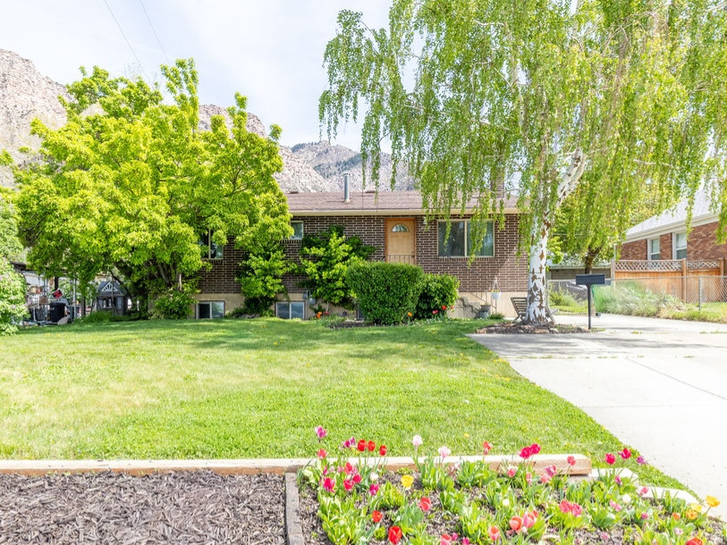 *Seller is willing to contribute towards closing costs.* Escape to your own private sanctuary in desirable East Ogden. This spacious rambler sits on a generous lot with stunning mountain views and room to grow. Offering approximately 2,400 square feet, this 4-bedroom, 2-bath home provides comfortable, accessible living with freshly painted interiors, abundant natural light, and a welcoming sense of openness throughout. The partially finished basement includes two bonus rooms with the potential to be converted into additional bedrooms, adding flexibility for future needs. Each level features a bathroom, while the roomy kitchen and living areas are ideal for gathering and entertaining. Designed to accommodate wheelchair access, the home offers ease and functionality without sacrificing style. Recent updates include the installation of new basement windows, the water heater, the garbage disposal, concrete driveway, and an upgraded AC system.  The true showstopper is the outdoor space. Located just minutes from the Douglas Street Trailhead, you'll enjoy quick access to exceptional hiking and mountain biking, along with breathtaking mountain views right from your expansive lawn. The wide, deep, fully fenced yard offers privacy and security for pets and play. A large garden plot, mature fruit trees, and grapevines invite you to enjoy harvesting your own produce and hosting memorable garden gatherings. Additional features include a large Tuff Shed for storage and an extended driveway with space for RV parking. This incredible property is just a showing away-don't miss the opportunity to make it yours!