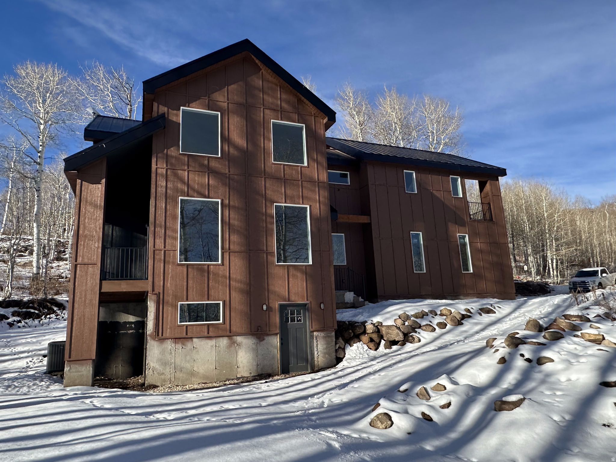 Don't pass up this chance for instant equity. Experience the perfect blend of modern luxury and mountain serenity in this brand-new mountain modern home, thoughtfully designed and nestled on a private, tree-filled lot with breathtaking mountain views. Tucked away for ultimate privacy, this property offers the peace of a secluded retreat with the convenience of year-round access on an alternate plow route. Step inside to a striking great room where vaulted ceilings, a cozy fireplace, and expansive windows create a light-filled sanctuary that connects seamlessly to the natural surroundings. Real hardwood floors flow throughout the home, enhancing its warmth and timeless elegance. The spacious layout includes large bedrooms with oversized closets, providing ample storage and comfort. The primary suite is a true escape, featuring its own private balcony, a generous walk-in closet, and a luxurious en-suite bath with separate soaking tub and shower. Designed for ease and function, the laundry room is conveniently located on the second floor, just steps from the bedrooms. The daylight basement expands your living space with a second family room, an additional bedroom, and a full bath - perfect for guests, a home office, or a media retreat. Built with attention to every detail, this home combines the beauty of nature with the sophistication of modern living. Whether you're relaxing by the fire, entertaining in the open living spaces, or enjoying the panoramic views from your balcony, this home is mountain living at its finest.