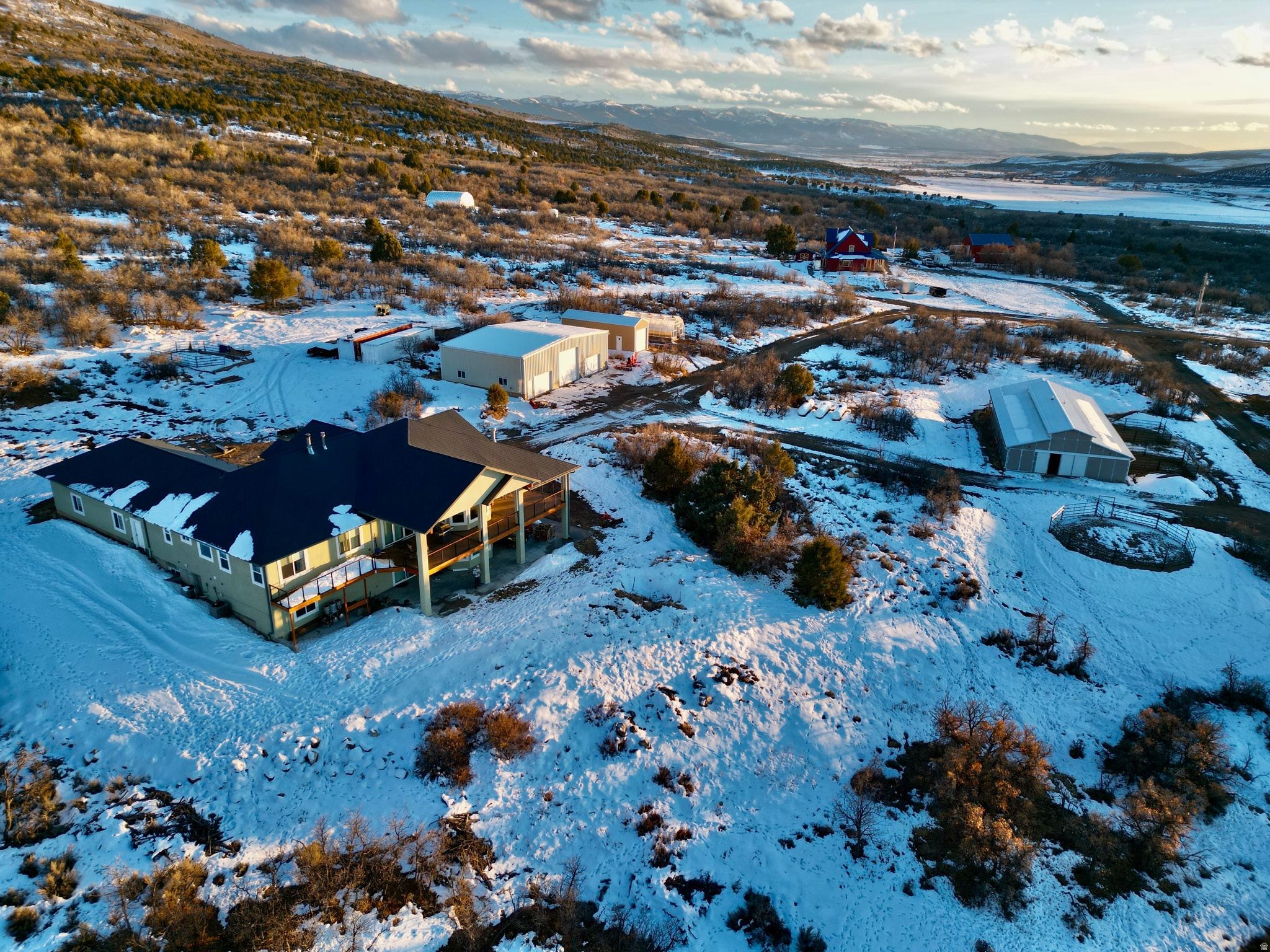 This exceptional 16.1-acre equestrian estate in Milburn, Utah, offers a rare blend of luxury, functionality, and breathtaking scenery. Designed for serious equestrians, it features a 6000+ square foot home, 5 stall barn and exceptional 12,000 square foot partially enclosed riding arena with professional-grade footing. The riding arena features WiFi controlled lighting and heating, dust control, and mirrors for rider training. The removable Marine-grade vinyl windows provide year-round comfort while preserving stunning views, and radiant heaters ensure warmth in colder months. The arena is equipped with snow guards, LiftMaster-operated doors, and a 1750 gallon rainwater collection system for sustainable maintenance. An included Arenavator helps maintain ideal footing conditions. The five-stall heated horse barn is meticulously designed for efficiency, comfort, horse health, and safety. It features five 12' x 16' stalls, two of which can be reconfigured to one 20' x 16' foaling stall. All stalls have Dutch doors; two have attached walk out pens. The wash rack with heated water, washing machine, plus the dedicated tack and feed rooms facilitate top-level care. The barn's raised center aisle design, insulated roof, and Piranha fly spray system ensure a comfortable environment. Additional equestrian amenities include a manure spreader, round pen, configurable turnout pens, and a well-planned layout for ease of care and horse movement. Beyond equestrian features, the estate includes a 5,000-gallon water storage, a 50kVA electrical service with a Generac backup generator, and a pre-installed solar transfer switch. Hardwired Cat5e Ethernet and WiFi access points in every structure provide seamless connectivity, while a Lorex security system offers remote monitoring for safety. With the mobile application, monitoring is available from anywhere with cellular service. The custom, sophisticated 6,000+ sq. ft. home is designed for comfort and convenience, featuring an open floor plan with expansive windows showcasing stunning mountain and valley views. The main-level master suite includes a cedar-lined walk-in closet and spa-inspired bath. The gourmet kitchen boasts Thermador appliances, Subzero refrigeration, trash compactor, and granite countertops - perfect for both everyday use and entertaining. The 1,000-square-foot Trex wraparound deck with remote-controlled sun screens extends the living space outdoors. The attached oversized three car garage provides ample parking for your vehicles. The lower-level walkout basement offers two additional bedrooms, a full bath with soaking tub, a kitchenette, a living area, two large storage rooms, and a built-in sauna. Additional features such as dual HVAC systems, tankless water heating, chandelier lift, heated exterior concrete, and pre-installed utility connections enhance convenience, efficiency and comfort. A 40'x60' workshop with insulation, with a radiant tube heater, three large garage doors, and plumbing for a restroom offers ample workspace and RV storage. The 14'x30' greenhouse with thermostatically controlled ventilation, water, and 240V/120V electrical service is built for year-round growing and the 12'x40' hay shed with rollup doors on either end provides easy-access and ample storage. With its state-of-the-art equestrian facilities, cutting-edge technology, and luxurious living, this estate is a rare opportunity for horse enthusiasts seeking the ultimate property in Sanpete County, Utah.