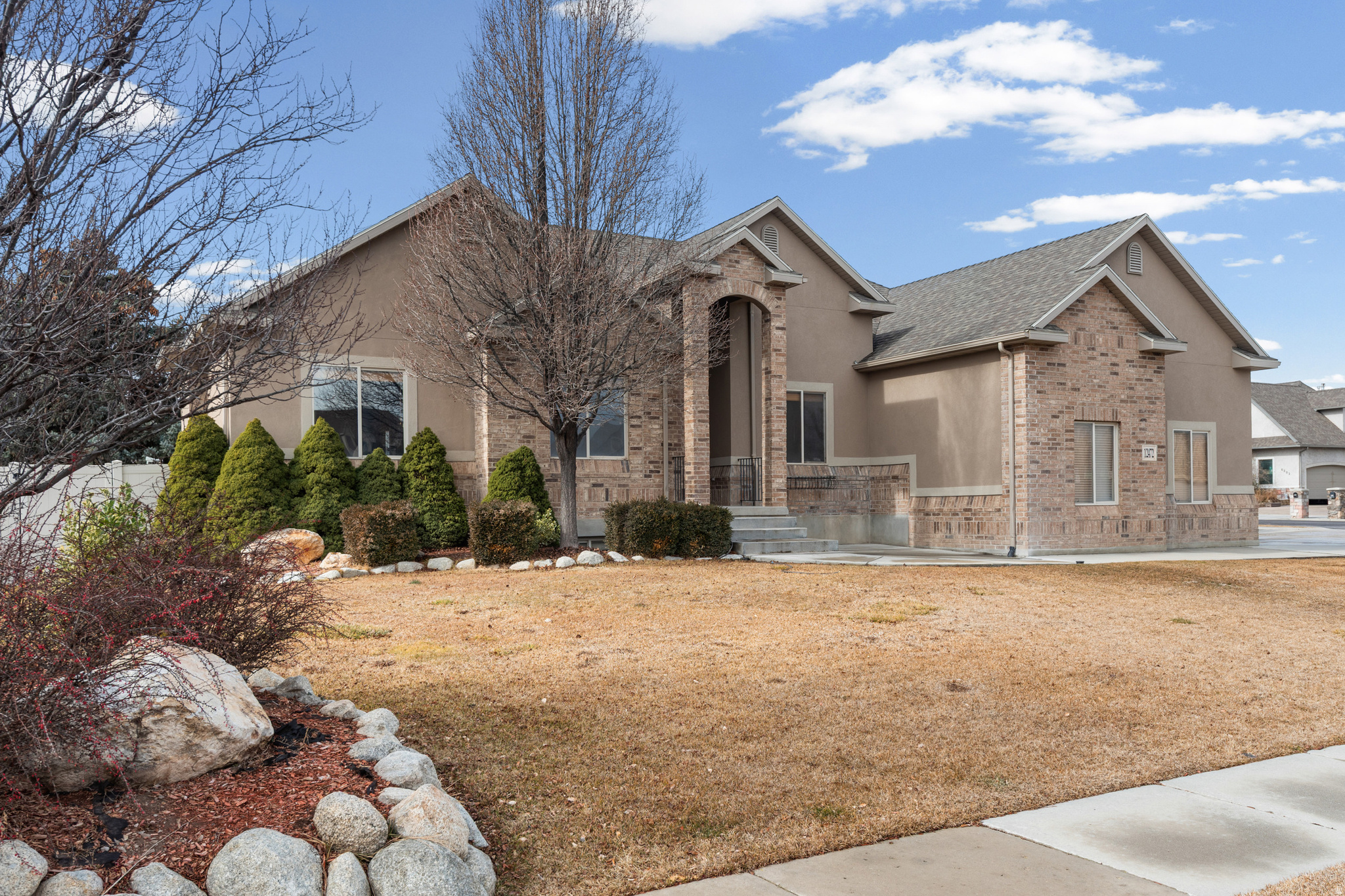 Nestled within the highly sought-after Heritage Place community, this distinguished all-brick residence offers a level of craftsmanship, durability, and timeless appeal rarely found in today's market. Encompassing 3,704 square feet, the home features 5 bedrooms and 3.5 bathrooms, thoughtfully designed to provide both comfortable everyday living and elegant entertaining.From its striking architectural presence with multiple roof gables to its enduring brick exterior, this home exudes quality and curb appeal from the moment you arrive. Inside, new carpet throughout creates a fresh and refined atmosphere, while the spacious floor plan offers exceptional flexibility for a variety of lifestyles. The well-appointed lower level includes a second kitchen and separate entrance, providing versatile living options for extended family, guests, or independent living arrangements. Every space reflects the care and pride of ownership that has gone into maintaining this exceptional property.Located in one of Herriman's most established and desirable neighborhoods, Heritage Place is prized for its mature setting, strong community appeal, and convenient access to both Herriman and West Jordan amenities. Combining timeless construction, generous living spaces, and an outstanding location, this is a rare opportunity to own a home built to stand the test of time.Square footage figures are provided as a courtesy estimate only and were obtained from previous MLS records. Buyer is advised to obtain an independent measurement.
