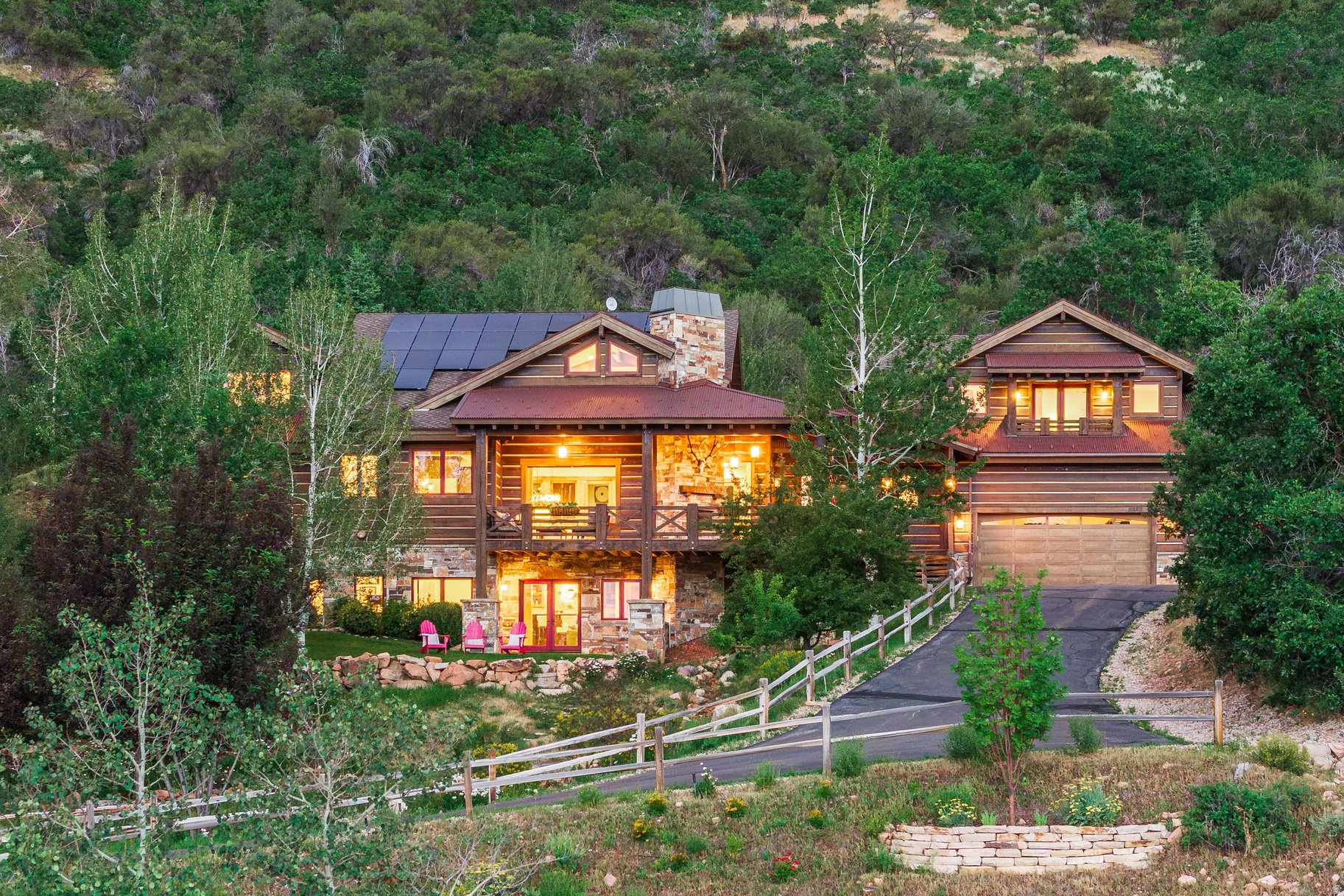 Nestled on approximately 11 private acres in the coveted Cove at Sun Peak, this exceptional mountain estate offers a rare combination of privacy, timeless craftsmanship, and breathtaking natural beauty just minutes from Canyons Village, Kimball Junction, world-class skiing, dining, and direct access to the Utah Olympic Park trail system. Thoughtfully positioned to capture sweeping mountain views, the property is surrounded by aspens, abundant wildlife, and a recirculating stream that creates a tranquil year-round water feature. Expansive covered decks and patios invite outdoor living, while a dramatic retractable glass wall seamlessly connects the great room to the main-level covered deck, creating an effortless indoor-outdoor lifestyle. Inside, soaring vaulted ceilings, exposed wood beams, rich wood flooring, and a floor-to-ceiling stone fireplace create warm, inviting living spaces. The chef's kitchen features Thermador appliances, granite countertops, a copper sink, custom stone range surround, a generous island, walk-in pantry, and built-in banquet seating. The main-level primary suite is a private retreat with its own covered balcony, a spacious walk-in closet, and a luxurious bath featuring dual vanities, soaking tub, and oversized shower. The upper level includes a private guest suite with a kitchenette and covered balcony and additional bedrooms. The walkout lower level is designed for entertaining with a spacious family room, wet bar, wine storage, flexible bonus spaces, abundant storage, and direct access to the covered front patio and beautifully landscaped yard. Additional highlights include radiant floor heating, air conditioning, solar panels, and an oversized three-car garage with a dedicated toy bay and exceptional storage. Offering an extraordinary balance of seclusion and convenience, this is a rare opportunity to own one of Park City's most distinctive mountain properties.