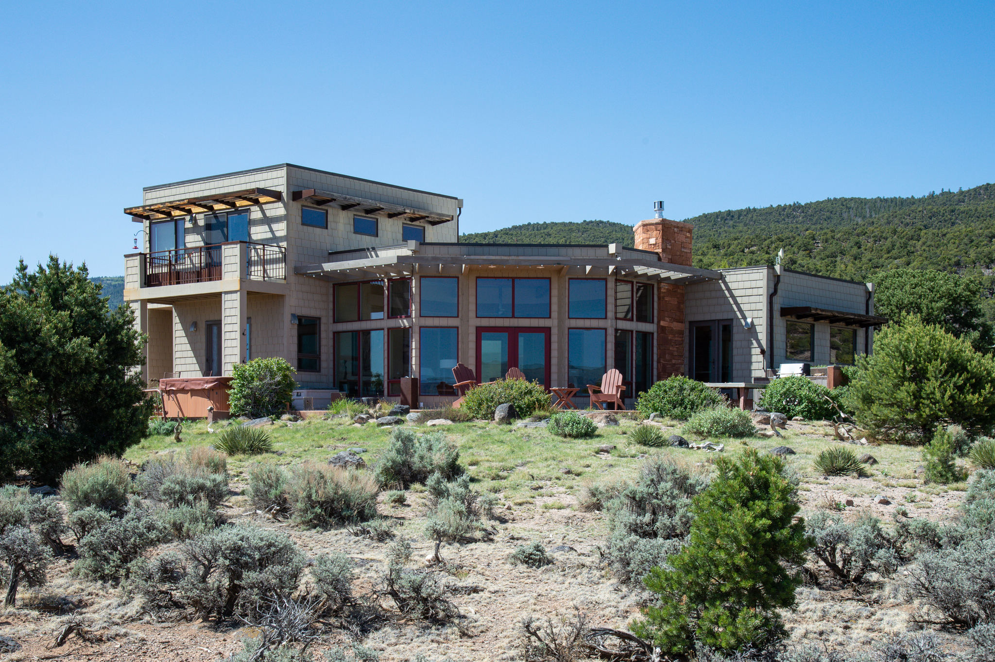 Designed by a renowned architect for its specific space and in keeping with the owner's wishes of privacy, view, and livability as a guide, this amazing home in the foothills of Boulder Mountain expresses all that the owner had hoped. There is a keen sense of harmony with the home, the land, the trees, the mountain, and the sky. Added to that, a new owner will have the luxury of both privacy and a protected, unspoiled view of the spectacular landscape. The full ten acres offers space, openness, and independence, along with the dynamic yet restful view. The extended entrance to the home creates a nice transition from the wonder of the outdoors to the striking great room and magnificent windows, displaying the colorful backdrop of red cliffs and blue sky. A few steps away, the kitchen, with its light and carefully placed windows, is a wonderful place to prepare and enjoy meals. A guest room and full bath are on the main floor, while the upstairs offers a generous master bedroom with a private ensuite bath and dedicated office space. The balcony from the master bedroom presents a breathtaking experience.  Surrounded by patios and sitting areas, the home offers the chance to find the ideal place to relish being outdoors at various times of the year. Beyond the home, the property includes a two-car garage with a greenhouse attached, and a charming studio.  For a visit to town, Torrey is only a ten-minute drive, offering coffee, lovely restaurants, and a Saturday Farmer's Market. World class hiking and exploring is nearby with miles of public lands everywhere. Only twelve miles away, Capitol Reef National Park is a terrific place to spend the day. Everywhere in the Boulder Mountain/Capitol Reef area is remarkable, and to have a home like this one to return to is even more remarkable.