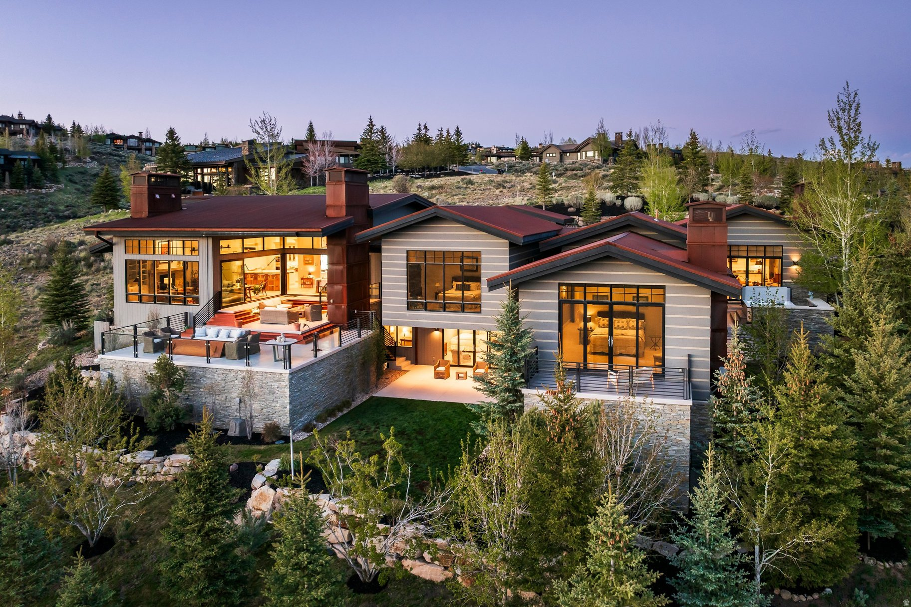 An exceptionally rare opportunity in Promontory's Painted Sky, a highly coveted neighborhood where only four homes have changed hands in the last five years. Occupying a prized cul de sac location with exceptional privacy and expansive views, this estate seamlessly blends natural topography with a refined mountain ranch aesthetic. Designed by revered Park City architect Clive Bridgwater, the home honors contemporary alpine architecture while delivering a fresh, light filled interior that avoids dark or dated mountain design tropes. An artful celebration of organic textures and natural light, the spectacular main level great room is framed by massive windows and expansive sliding glass doors that meet at the corner, dissolving the boundary between indoors and out to create the ultimate indoor outdoor living experience. The partially covered deck offers an outdoor living sanctuary with an integrated fireplace and separate fire-pit, creating a year round setting for enjoying legendary Park City sunsets. The thoughtfully designed main level features three luxurious bedroom suites, including a grand primary retreat with a fireplace and steam shower, along with an ingeniously designed bunk room suite featuring dual closets, a split bathroom with separate vanity spaces, and its own adjacent family room, creating an ideal gathering space for children and guests. The gentle downhill topography allows the lower level to transition seamlessly into a bright walk out living space featuring a fourth private bedroom suite. Complete with a spectacular heated four plus car garage, this exceptional estate borders protected open space, offering a rare combination of privacy, architectural excellence, and timeless mountain living. There is a full membership available.