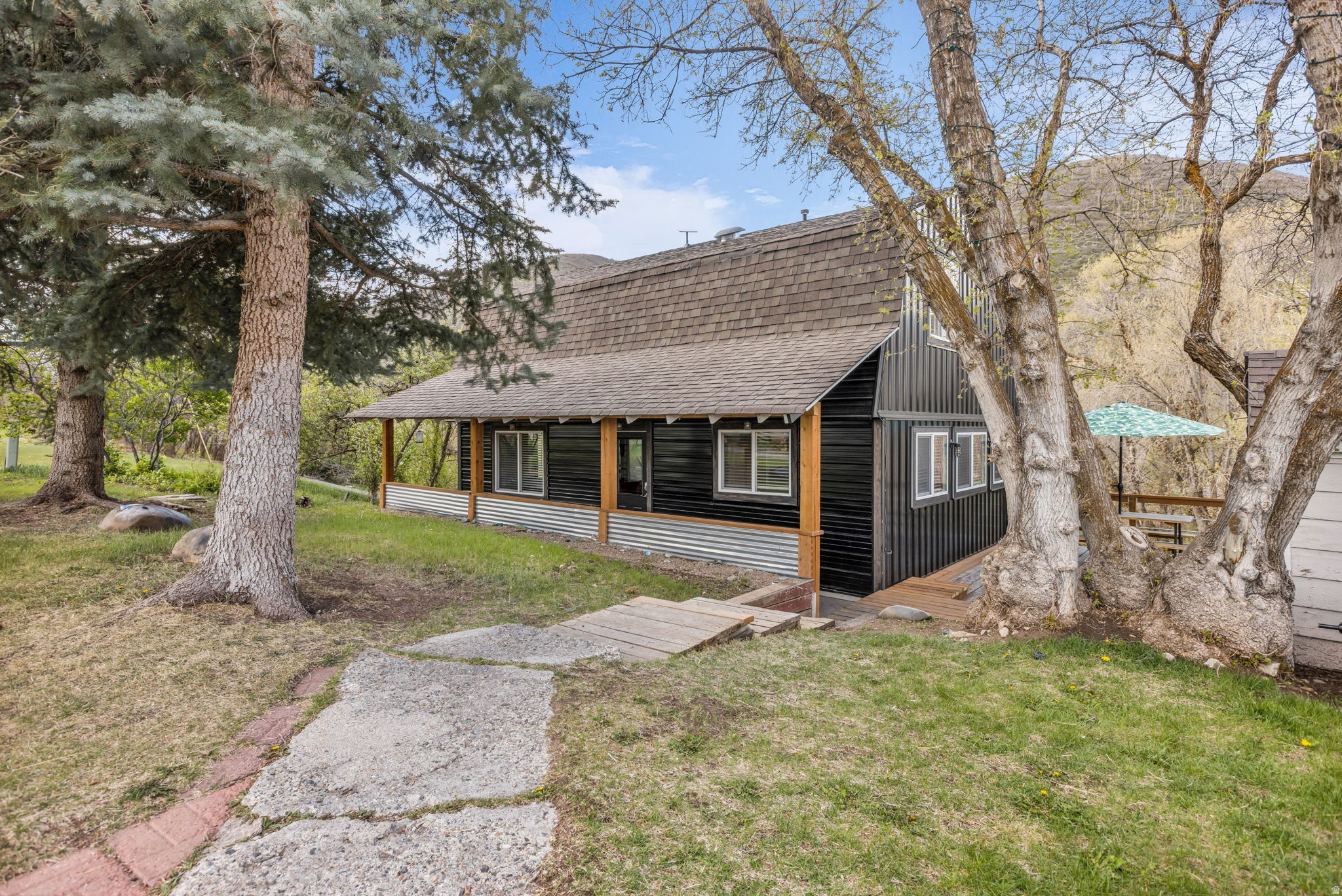 This is a rare opportunity to own a full acre of usable land in a peaceful, natural setting, with Daniel's Creek running along the backyard. Horses and other large and small farm animals are welcome, supported by a dedicated pasture and an enclosed shelter space designed for their comfort and care. Free from HOA restrictions, the property offers a level of flexibility that is increasingly hard to find, giving you the freedom to truly make it your own. The property features a charming, updated 4-bedroom, 3-bath cottage that is move-in ready, offering a warm and inviting space to enjoy immediately while still allowing for future possibilities. A versatile flex space adds even more functionality, ideal for a home office, gym, or additional sleeping area. Thoughtful upgrades include new flooring and paint throughout, new exterior siding, a brand-new kitchen, and new decking and stairs. Outdoor living truly stands out, highlighted by an expansive balcony overlooking a peaceful backyard sanctuary, creating the perfect setting for both entertaining and quiet relaxation. Ideally located just minutes from downtown Heber, you'll enjoy easy access to local shopping, dining, and everyday amenities, while still being surrounded by Utah's most sought-after recreation. The Uinta Mountains are nearby for hiking, camping, and off-road adventures, along with Deer Creek and Jordanelle Reservoirs for boating, paddleboarding, and fishing. World-class skiing, including Deer Valley and Sundance, are all within close reach, making this an ideal base for year-round mountain living. With an acre of land, a water share, freedom, and unmatched access to both convenience and recreation, this is a rare opportunity where value and lifestyle come together, and the price truly can't be beat.