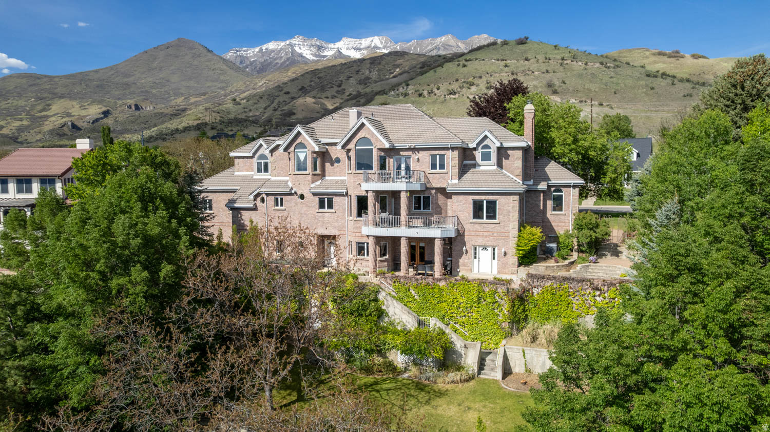 Stunning panoramic valley views await in this architectural masterpiece perched on the Orem hillside. Built with commercial-grade steel beam construction, this extraordinary 4-story estate blends luxury living with unparalleled entertainment. The grand floor plan features high-quality cherry and maple cabinetry, two full kitchens with gas ranges, and a dedicated dual-desk home office. An entertainer's dream, the property boasts a private indoor racquetball court, a tiered theater room, and a spectacular resort-style backyard complete with a cascading waterfall, a large pavilion, a putting green, and a playset-perfect for hosting unforgettable weddings and large gatherings.The top-floor primary sanctuary offers an exclusive private balcony with breathtaking sunset and firework views. Accessibility is effortless across all levels via the private elevator. This estate also includes an integrated, high-income ADU apartment featuring three separate exterior entrances. Do not miss the immersive 3D virtual tour! Square footage figures are provided as a courtesy estimate only and were obtained from county tax records.  Buyer is advised to obtain an independent measurement.