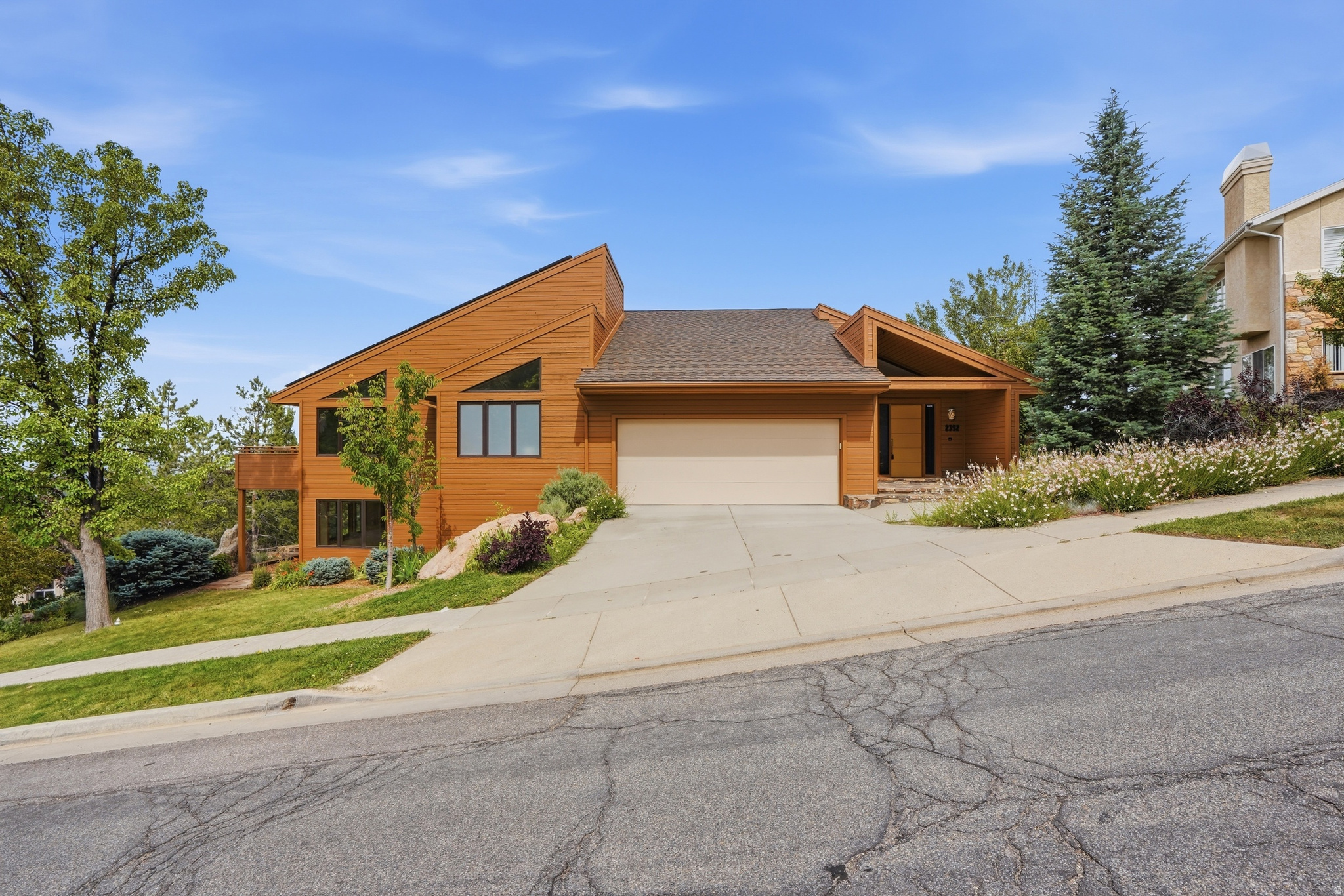 Offered for only the second time in 35 years, this architect-designed contemporary by Sako Chater is a rare East Bench offering. This home features expansive windows, soaring vaulted ceilings, skylights, and panoramic views of Mount Olympus, downtown Salt Lake City, the Great Salt Lake, bringing the outdoors in.  Recent updates include new hardwood flooring throughout the main living spaces, a renovated bathroom, fresh sod, and freshly repainted cedar siding in spring 2026. The remodeled kitchen is equipped with a Sub-Zero refrigerator, Thermador gas cooktop, custom cabinetry, and a curved granite island. The main-level primary suite offers direct patio access, creating a seamless connection to the outdoor living spaces.  Wrap-around decks, mature landscaping, fruit trees, garden beds, a private sauna, and hot tub create an exceptional setting for relaxing or entertaining. Located in one of Salt Lake City's most sought-after East Bench neighborhoods, with easy freeway access and walking distance to Foothill trails. An owned solar system, included in the sale, offsets approximately 95% of annual electrical usage. A rare combination of architectural character, thoughtful updates, efficiency, and location.
