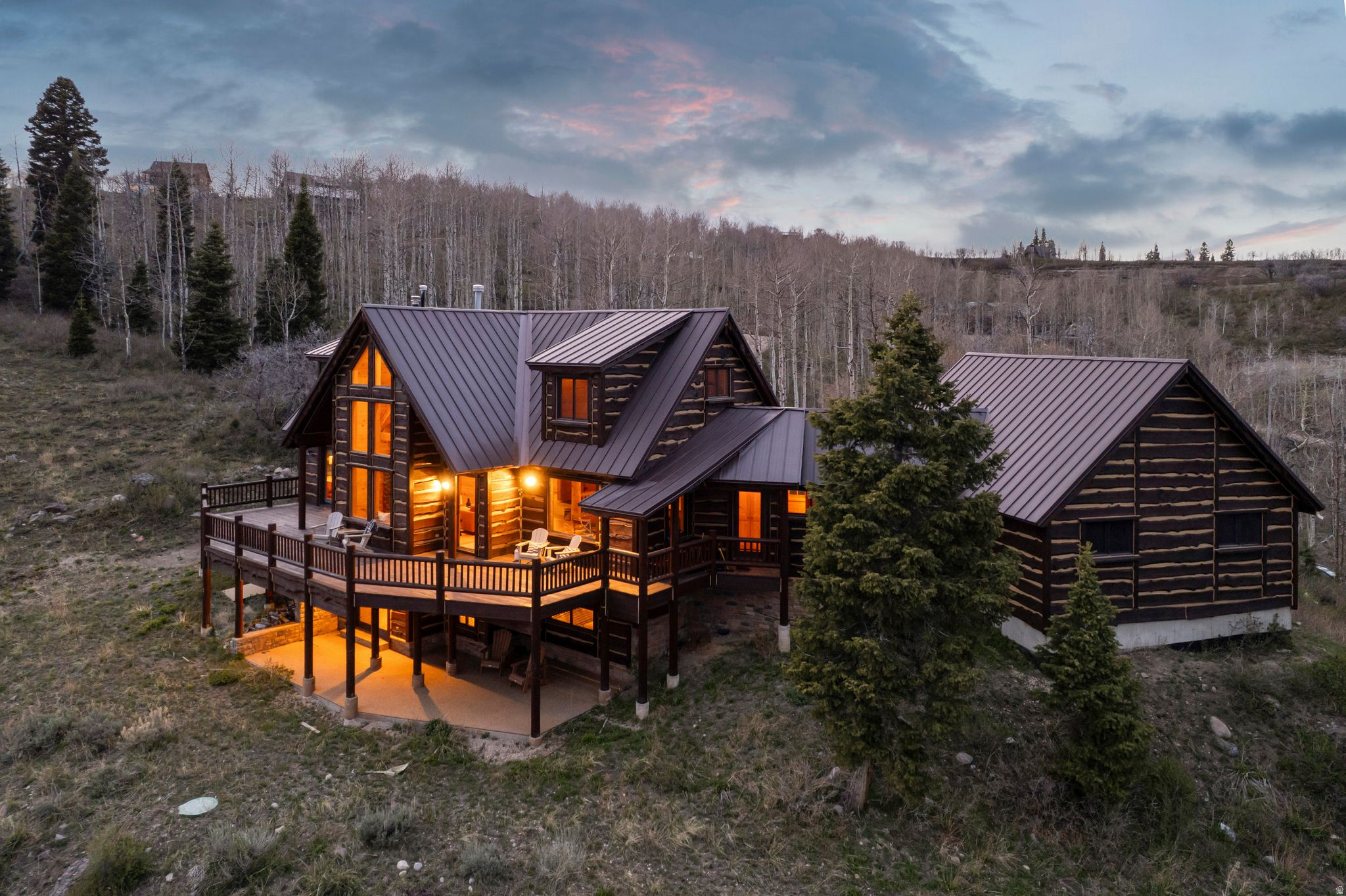 Perched on 2.68 acres featuring mature trees and dramatic rock formations, this stunning 4,068 square foot retreat is one of the most remarkable properties in Tollgate Canyon's Forest Meadows community. Oriented to capture sweeping 270-degree views of the Uinta Mountains and surrounding ski resorts, the cabin's massive back deck sets the tone the moment you arrive.  Step inside to an open floor plan designed to keep those views front and center. The great room anchors around a beautiful fireplace, while the main level primary suite opens directly onto the deck - seamlessly blending indoor comfort with the surrounding landscape. A well-appointed kitchen with granite countertops and a casual dining area round out the main level, all framed by the same breathtaking panorama.  Upstairs, a reading loft connects two bedrooms sharing a full bathroom - a perfect retreat for guests or family. The walkout basement expands the living space further with an additional bedroom, a bathroom featuring a steam shower, and a generous game room and TV area. Practical touches abound as well, including cold storage, an oversized laundry room, and a dedicated room with backup water tanks for added peace of mind.  Whether you're envisioning a cherished family legacy cabin, a high-performing nightly rental, or a full-time primary residence, this property delivers on every front. Radiant heat and an attached two-car garage add year-round comfort and convenience.  Tollgate Canyon offers the perfect mountain escape while being just moments away from modern conveniences - just 20 minutes from Whole Foods, 22 minutes from Deer Valley East Village, 29 minutes to Canyons Village Base, and 45 minutes from Salt Lake City International Airport.