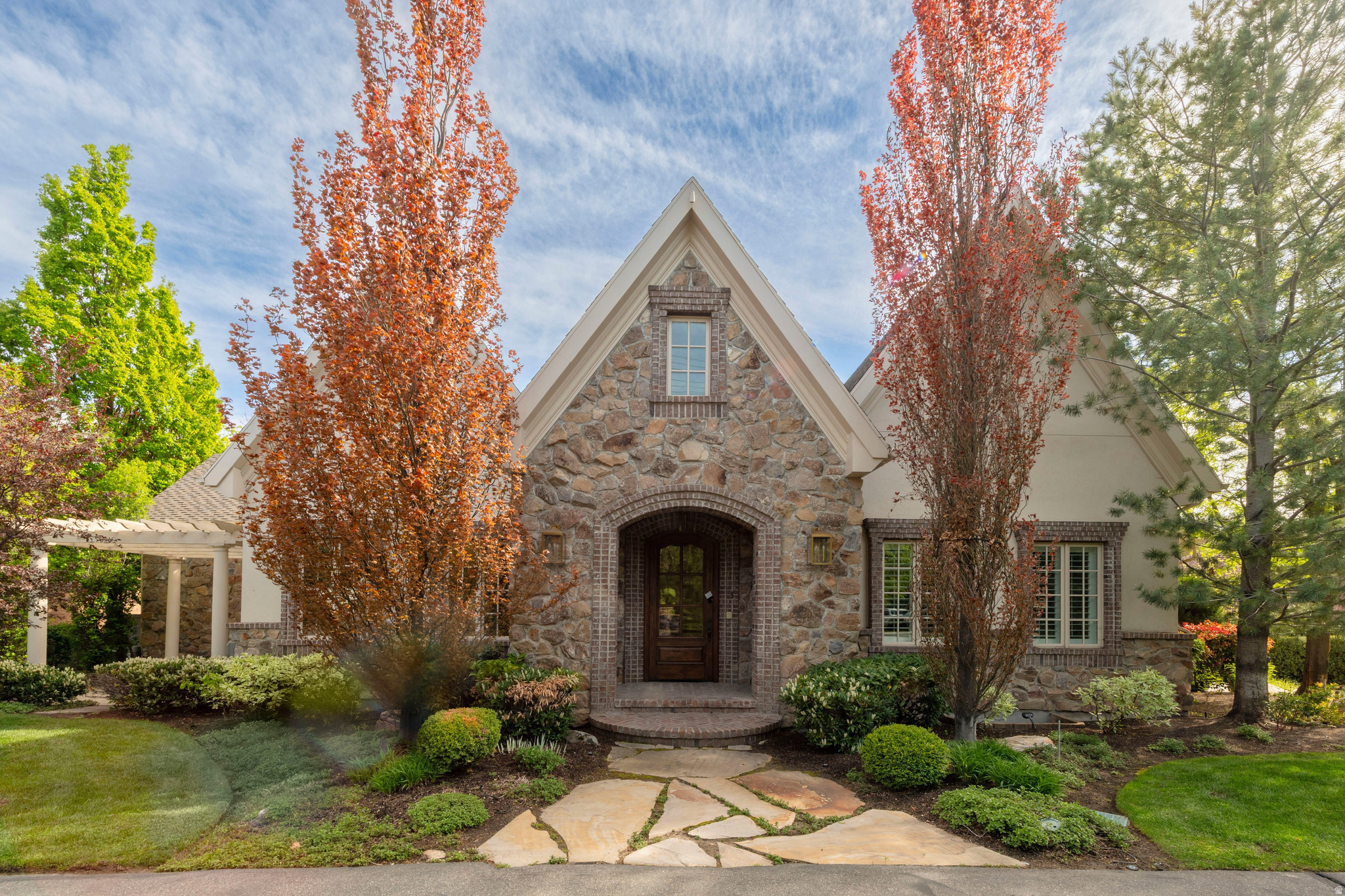 Charming stone and brick European style with soaring ceilings, wide-open spaces and truly fabulous millwork and finishes. Many tasteful updates by the original owner who has loved this home. Huge .65 acre lot with privacy, mountain views and a wonderful pool and spa! There is a detached oversized RV/boat garage plus an oversized attached double. Play court, circle drive and mature, park-like landscaping add appeal. The spaces include a grand entry, elegant formal living and dining rooms, a main floor office and spacious family rooms main and down. The main level primary has a freshly redone luxury European bath. The kitchen is all white, quartz slabs, and a great bay window overlooking your own private park. There are main and lower laundry facilities. Four large bedrooms are down. There is a ton of storage. Note the top floor secluded theatre! This house has it all, plus the ultimate location!