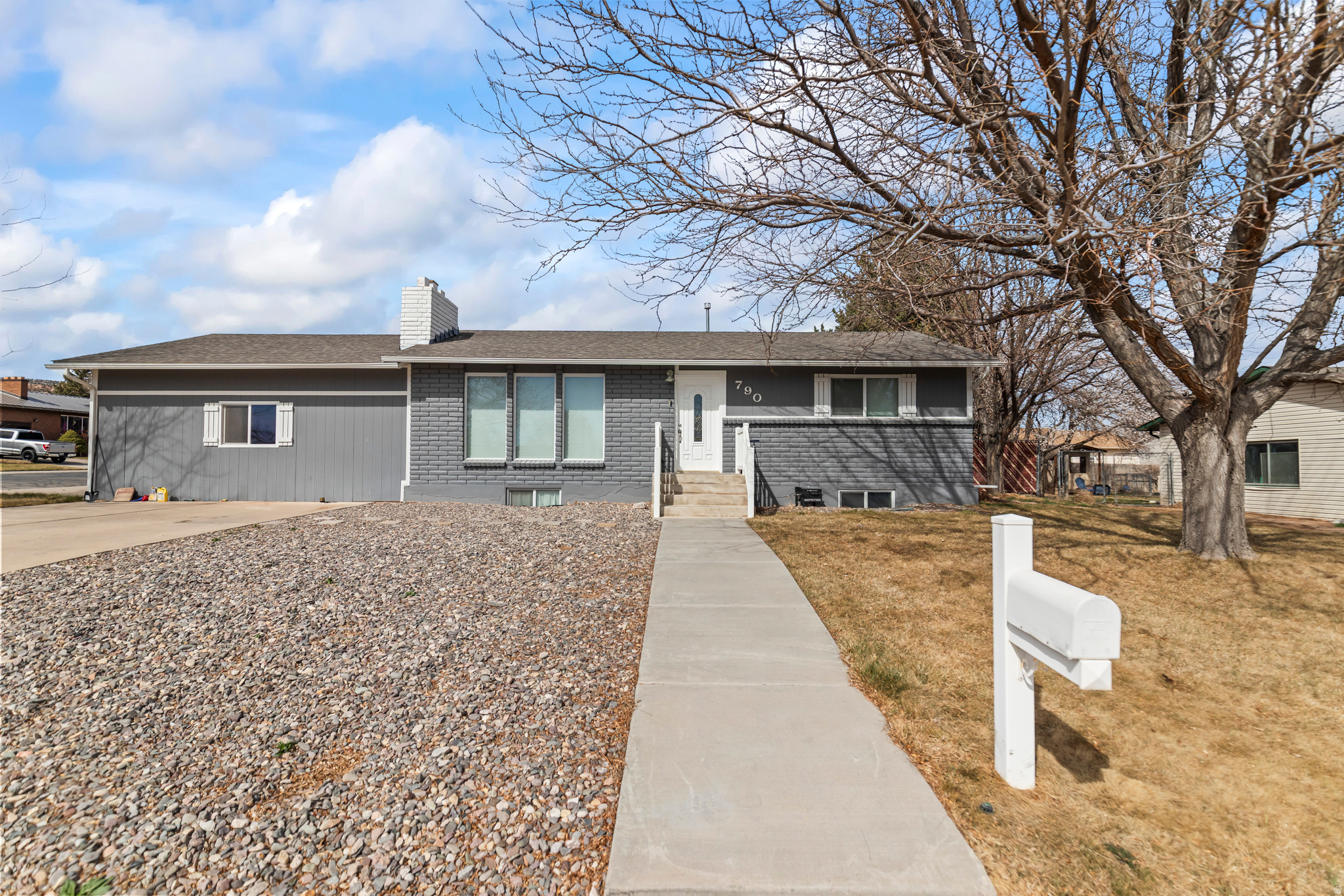 Move-in ready rambler with a rare 3-car garage! This beautifully updated 4-bedroom, 2-bath home offers 2,080 sq ft of comfortable living space, including a fully finished basement and a bright main-level living room filled with natural light from oversized windows. The updated kitchen features granite countertops, stainless steel appliances, and two pantries for exceptional storage. Recent updates include bathrooms, paint, flooring, and lighting, giving the home a fresh, modern feel throughout.  Downstairs, enjoy a cozy family room with a charming brick fireplace-perfect for relaxing or entertaining. Situated on a landscaped corner lot, the yard features mature trees, fruit trees, automatic sprinklers, and a covered patio ideal for outdoor gatherings. The swing set, trampoline, and storage shed are all included. The attached 3-car garage offers plenty of room for vehicles, toys, and projects, complete with a workbench and overhead storage. Conveniently located within walking distance to parks, schools, and trails, this home offers the perfect blend of comfort, function, and location.