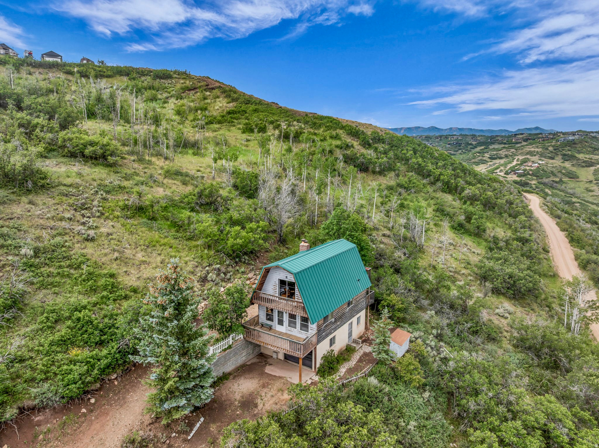 Escape the summer heat while enjoying lake views from this rustic mountain retreat. Whether you're looking for a seasonal getaway or a year-round residents -as some owners in this gated community have chosen-this property offers an incredible opportunity.  This fixer-upper cabin is ideal for buyers seeking value, privacy, and the chance to create their own mountain escape. Currently the lowest-priced single-family home on two acres in Summit County, it offers exceptional potential.  The cabin sits on a 1-acre parcel, and an adjacent 1-acre lot with a separate tax ID (LR-2-171) may be included with a reasonable offer, bringing the total property size to 2 acres.  Utilities include: a septic system, electric baseboard heat, two wood-burning stoves that add warmth and mountain charm.  And culinary water through the community HOA well.  Outdoor enthusiasts will appreciate the property's proximity to Rockport Reservoir, offering boating, fishing, and paddle boarding. Park City is just 25 minutes away via Kimball Junction, providing convenient access to world-class skiing, dining, shopping, and entertainment. Enjoy skiing and snowboarding at Park City Mountain Resort or the renowned ski-only experience at Deer Valley Resort.  Summit County is an outdoor paradise, featuring more than 400 miles of motorized single-track trails and over 500 miles of non-motorized biking and hiking trails. Adventure, relaxation, and mountain views await-schedule your showing today.