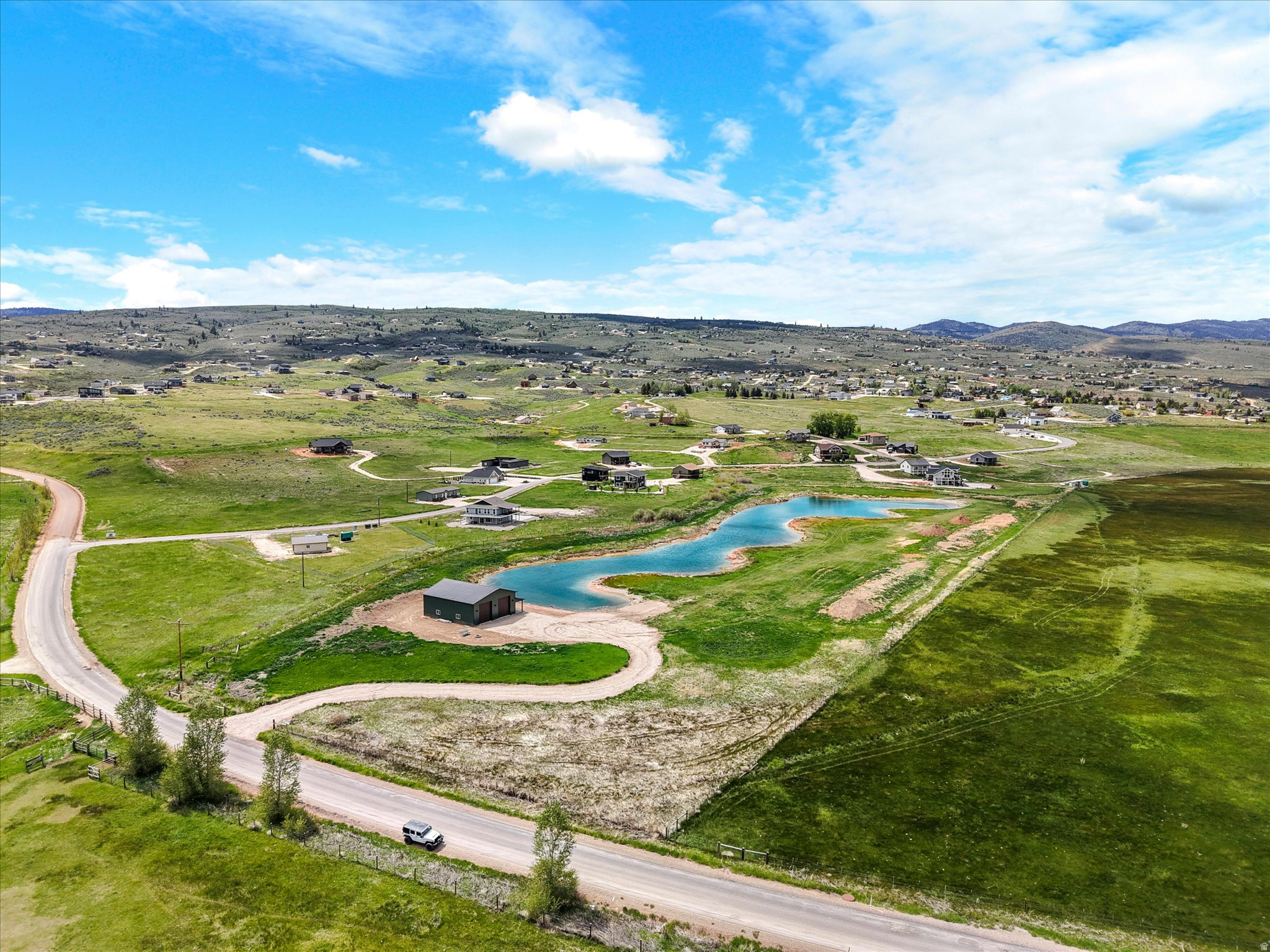12-acre property with a 2,000 sq ft shop fully equipped, in Garden City, a private 2.5-acre pond, commercial zoning. Located along Sweetwater Parkway, this exceptional property offers mountain scenery and endless potential for residential, recreational, commercial use or subdivision development. The 40x50 shop includes 14-foot doors, 200-amp power, an 8x50 covered porch, finished full bath, sewer connection, and water service through the Bear Lake Water Company. The professionally constructed pond is clay lined, approximately 2.5 acres in surface area, and reaches depths of 1018+ feet, creating a beautiful centerpiece that attracts wildlife and enhances the peaceful setting. Additional features include a 172-foot well producing approximately 30 GPM, 12 shares of Hodges Irrigation water, and power extended along the north boundary. Just minutes from public beaches, Bear Lake recreation, and surrounding mountain ranges with hundreds of miles of ATV, hiking, snowmobiling, and horseback riding trails, this property offers the perfect blend of lake living, outdoor adventure, and investment opportunity.