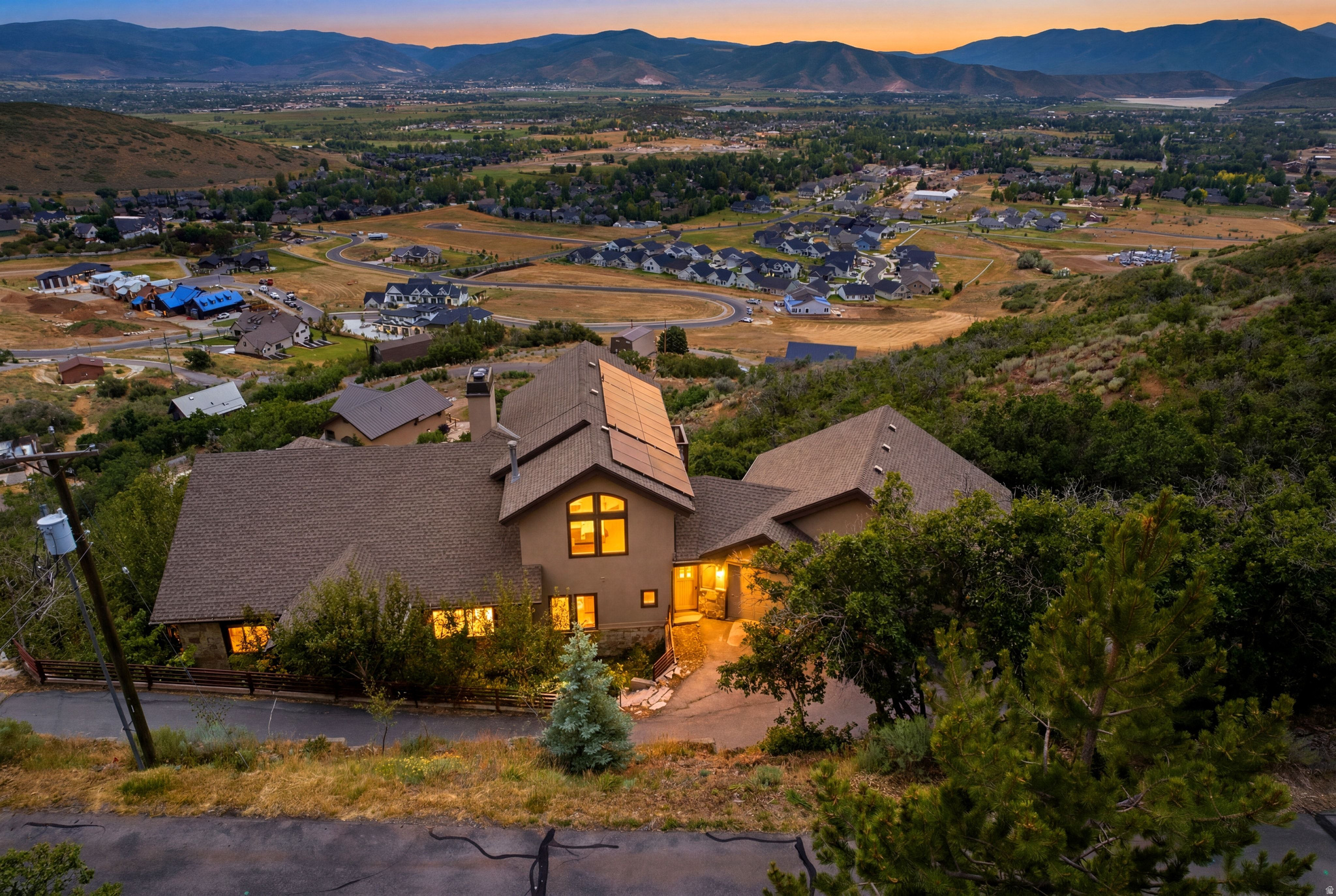 Panoramic Midway Mountain Retreat with Valley Views, Guest Quarters and Resort Proximity. Perched high in Midway's sought-after Interlaken community, this exceptional mountain retreat offers a private setting with breathtaking panoramic views across the Midway and Heber valleys, Deer Creek Reservoir, and Mount Timpanogos.Thoughtfully designed across four levels, the home combines timeless craftsmanship with everyday comfort, featuring radiant heat, Pella windows, central air, and laundry facilities on every level as well as four fireplaces. With six bedrooms, five full bathrooms, and multiple flex spaces for additional sleeping, home offices, or entertainment, the residence easily accommodates large gatherings, multigenerational living, or rental opportunities. The spacious kitchen and dining area frame spectacular sunrise-to-sunset views and flow seamlessly into the vaulted great room anchored by a dramatic double-sided fireplace. Upstairs, the private primary suite offers its own balcony, gas fireplace, spa-inspired bath, and generous walk-in closet or office. The entertainment level features a family room, home theater, wet bar, three bedrooms, and two full baths. The walkout lower level offers privacy to guests or renters and includes a full kitchen, wood-burning fireplace, family room, laundry, and two bedrooms with a full bathroom. An unfinished elevator shaft offers future accessibility. There is a three vehicle garage on the main level and an oversized lower garage for recreational vehicles and mountain toys with an adjacent workshop and abundant storage. Enjoy quick access to Guardsman Pass, Wasatch Mountain Park, Midway's charming Main Street, Deer Valley East Village in just 20 minutes, and Historic Main Street, Park City, in approximately 25 minutes.