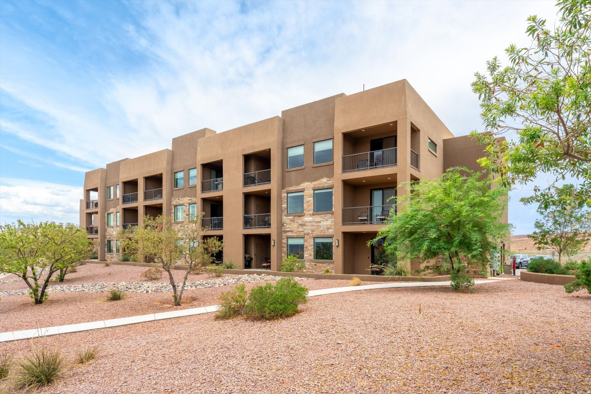 Nightly rental approved and just minutes from Sand Hollow Reservoir, this beautifully appointed 2 bedroom, 2 bathroom condo offers the perfect blend of investment potential, vacation living, and Southern Utah adventure. Whether you're expanding your short-term rental portfolio, searching for a second home, or looking for a lock-and-leave getaway, this turnkey property is ready to enjoy.  Inside, the open-concept floor plan is filled with natural light and features granite countertops, rich wood cabinetry, stainless steel appliances, abundant storage, and a spacious island with bar seating. The kitchen flows seamlessly into the dining and living areas, creating an inviting space for entertaining and relaxing.  The split-bedroom layout provides privacy for owners and guests. The spacious primary suite offers direct access to the oversized covered balcony and an ensuite with dual vanities, granite countertops, a soaking tub, separate walk-in tiled shower, and generous storage. The second bedroom comfortably accommodates two queen beds, maximizing rental flexibility. A second full bathroom and dedicated laundry room add convenience.  Step outside to the expansive covered balcony overlooking the resort-style pool while enjoying sweeping views of the surrounding desert landscape, red rock mesas, and distant mountains.  Residents and guests enjoy a sparkling pool, hot tub, elevator access, beautifully maintained grounds, and ample parking. Ideally located just minutes from Sand Hollow State Park, championship golf, boating, wake surfing, paddleboarding, fishing, hiking, biking, world-class ATV trails, and Zion National Park, this condo places endless recreation at your doorstep.  With desirable nightly rental zoning, outstanding amenities, breathtaking views, and an unbeatable location, this is an exceptional opportunity to own an income-producing vacation property and your own private desert retreat.