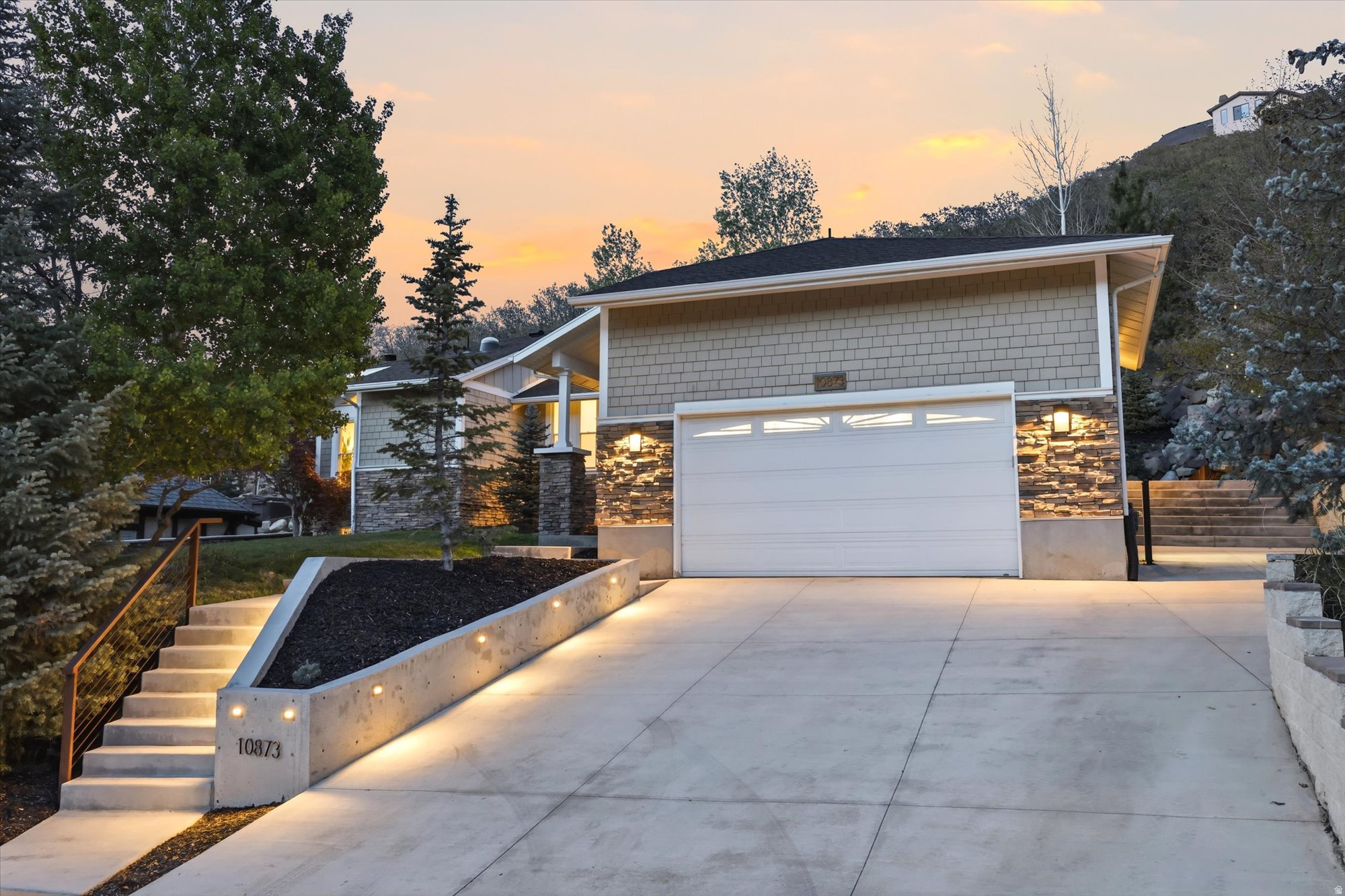 This stunning 5-bed, 3-bath custom-built rambler is a true modern industrial masterpiece-perfectly blending warmth, character, and high-end design. Thoughtfully curated with luxurious finishes throughout, the home features a showstopping chef's kitchen anchored by a dramatic 15-foot center island with Taj Mahal quartzite countertops, complemented by corten steel accents, clear alder cabinetry, and striking honeycomb calcite pendant lighting. Top-of-the-line appliances include a 60" Viking Professional Series cooktop, Monogram refrigerator, Bosch dishwasher, and a sleek 60" stainless steel hood. Exotic Guanacaste wood, exposed beams, skylights, limestone accent walls, a built-in breakfast nook, and dedicated office space elevate both form and function. The main-level primary suite offers a private retreat with vaulted ceilings and a spa-inspired en-suite featuring a steam shower with triple heads, separate soaking tub, bidet, laundry chute, cedar paneling, custom closet system, and a statement barn door. All bathrooms have been beautifully remodeled with cohesive honeycomb and steel design elements. The lower level includes a functional workshop, an ideal floor plan, and additional access to the oversized 2-car garage with mezzanine entry to the kitchen. Set on a serene and private half-acre, the outdoor living is equally impressive-featuring an in-ground hot tub, terraced backyard staircase, and a redwood deck with firepit where you can take in breathtaking 360-degree views of the mountains, canyon, and valley.