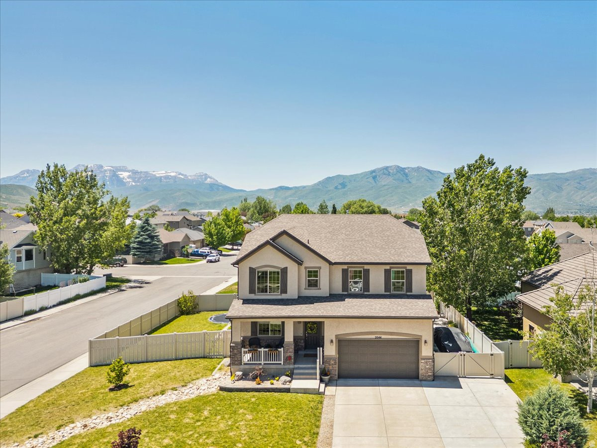 Beautifully situated in the heart of Heber City, this inviting two-story home offers comfortable living, thoughtful outdoor space, and incredible views of Mount Timpanogos. The home sits on a spacious corner lot with mature trees, a fenced yard, garden boxes, patio space, and room to enjoy the Wasatch Back lifestyle. Inside, you'll find a bright and functional floor plan with multiple gathering areas, large windows that bring in natural light and mountain views, and an open kitchen and dining area that flows easily into the main living space. The covered front porch adds charm and curb appeal, while the backyard provides a peaceful setting for relaxing, gardening, or entertaining. Conveniently located near schools, parks, downtown Heber, Reservoirs, Deer Valley East Village and world-class recreation in Park City, this home offers a great combination of location, views, and everyday livability.  Square footage figures are provided as a courtesy estimate only and were obtained from an appraisal.  Buyer is advised to obtain an independent measurement.