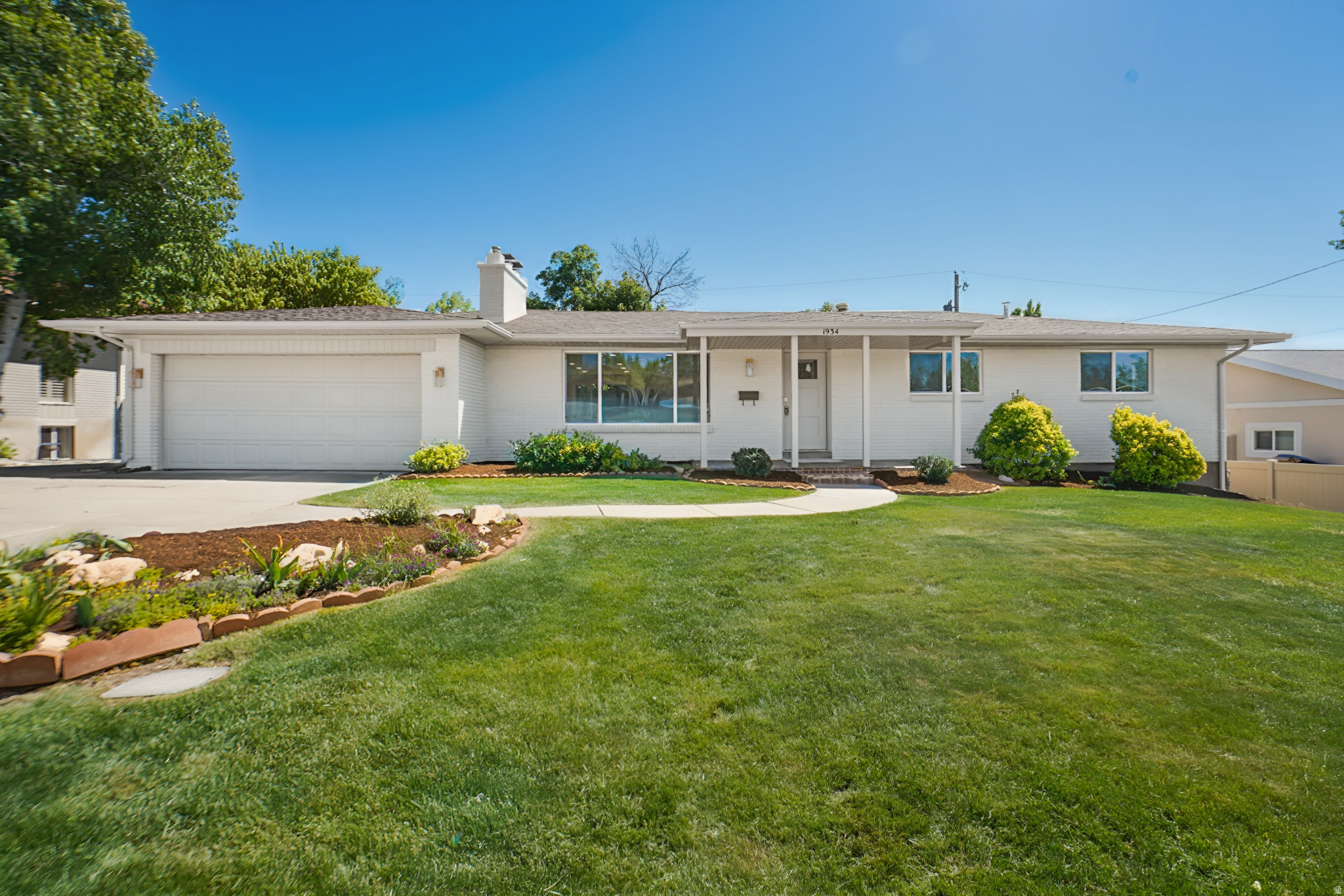 Exquisitely remodeled rambler in the heart of Holladay, offering refined single-level living in a highly desirable neighborhood. Designed with a warm modern aesthetic, this turnkey home features an open-concept layout filled with natural light and elevated finishes throughout.  The designer kitchen anchors the home with quartz countertops, an oversized island, and rich wood cabinetry-perfect for both everyday living and entertaining. The spacious primary suite includes a walk-in closet, while beautifully updated bathrooms showcase clean, timeless design.  Enjoy the rare convenience of laundry on both levels, a two-car garage, and seamless indoor-outdoor living. The fully fenced backyard offers no rear neighbors and a covered patio, creating a private, peaceful retreat.  Ideally located near Holladay Village, Big Cottonwood Canyon, and I-215, this home blends tranquility, accessibility, and modern comfort.
