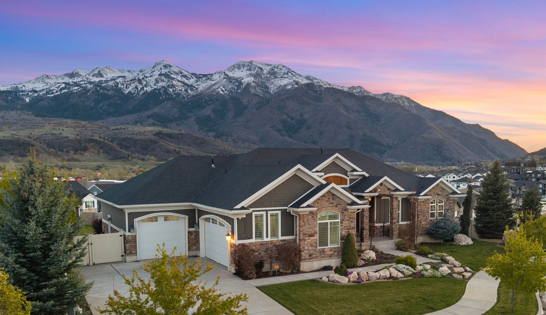 Set in scenic Mountain Green with the most spectacular views of Lewis Peak and Snowbasin Ski Resort, this custom-built, meticulously maintained home offers exceptional quality and comfort throughout.  The main level welcomes you with vaulted ceilings and a bright, open layout that seamlessly connects the living spaces. The kitchen is built to impress, featuring a large island, granite countertops, dual ovens, a gas cooktop, and a water purification system, all opening to the dining area and great room with a cozy gas fireplace. You'll also find a private office or den, a spacious primary suite complete with a separate walk-in shower, dual quartz vanities, and a large walk-in closet with custom built-ins. Additional highlights include plantation shutters, automatic shades, central vacuum, and a finished garage with overhead storage. The fully finished daylight basement expands your living space with a large family room, theater room with a dry bar, two generously sized bedrooms, a full bath, and a large storage room with built-in shelving. Located within walking distance to Morgan Jr. High and just minutes from Snowbasin Resort, Pineview Reservoir, and Ogden Valley, this is a rare opportunity to own one of the most beautiful homes in the sought-after Rollins Ranch community. Don't miss it!