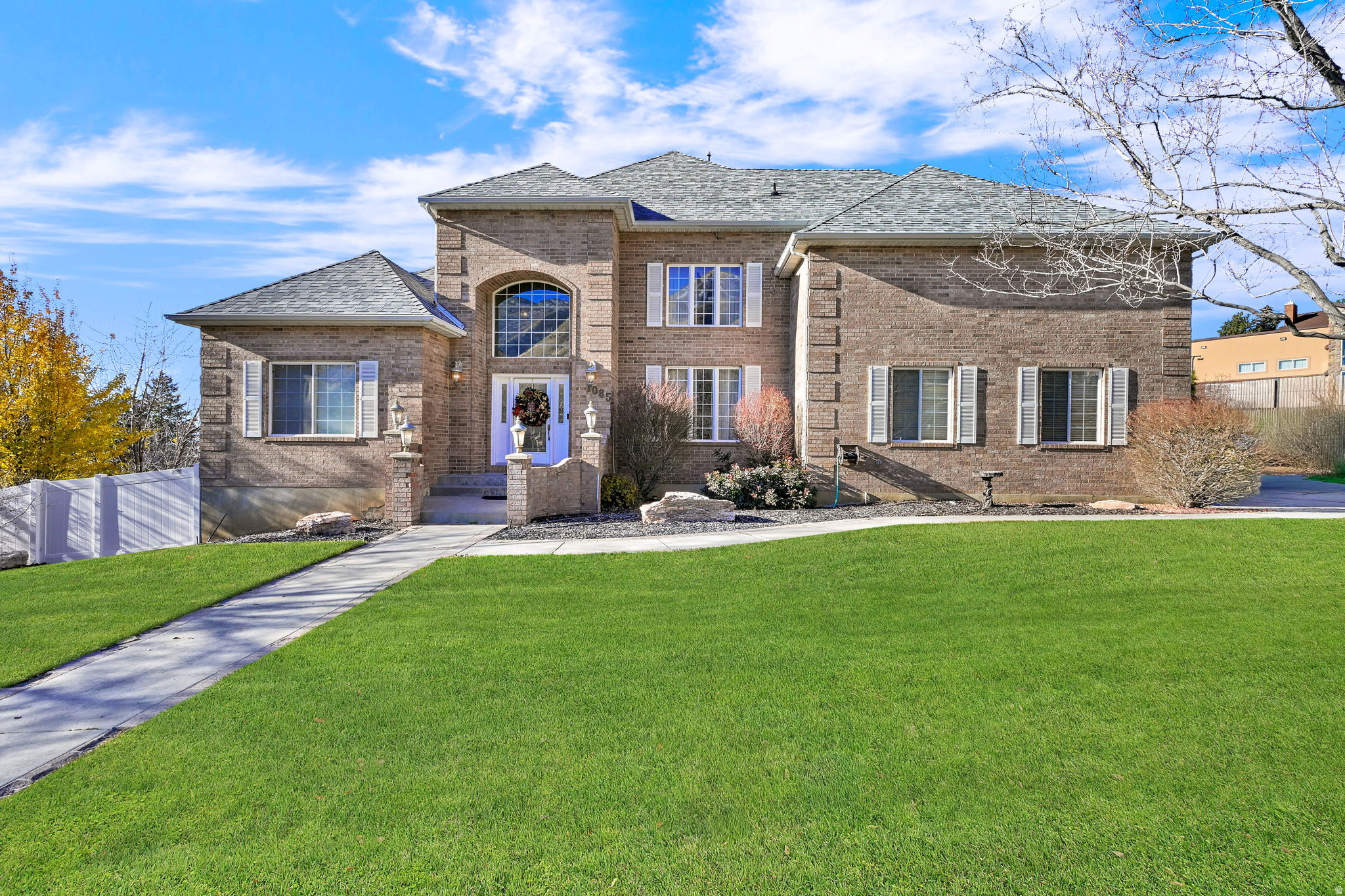 BACK ON THE MARKET - Previous Buyers cancelled because their home did not sell. AMAZING VIEWS of the valley and all of Utah Lake from this custom-built, all-brick home. Uniquely, this sale includes an adjoining, fully improved second lot to the north, providing ample space to accommodate all your recreational needs, including boats, RVs, toy trailers or even a second dwelling. Step inside to a show-stopping entry featuring soaring 20-foot vaulted ceilings and a breathtaking chandelier equipped with a lift system. The exceptional floor plan is designed for main-floor living, highlighted by 12-foot ceilings throughout the main level and a formal living and dining area. At the heart of the home is an extra-large kitchen with custom oak cabinetry bar seating, and a spacious eating area. The main floor master suite is a true retreat, boasting a jetted tub and French doors that open onto a Trex deck, offering romantic sunset views overlooking the lake. This home is uniquely designed with master suites on all three levels, offering incredible flexibility for multi-generational living. The upstairs features bedrooms connected by a Jack-and-Jill bathroom, along with a third large vaulted bedroom with its own private full bath. The 100% finished walk-out basement is a standout, featuring an additional master suite with a second jetted bath, separate shower, and two huge walk-in closets. Ideally suited for security and storage, one closet includes a hidden vault door for safekeeping. Outdoor entertaining is effortless on the ginormous Trex deck, which features gas access for a firepit and outdoor heaters. Below, a huge, stamped concrete patio invites you to enjoy the fully fenced yard and the majestic wildlife in your own backyard.  Your mind will be at ease, because the home features a brand-new roof, two water heaters, a double furnace, and 220V wiring ready for a hot tub or electric vehicle. A spacious 3-car garage completes this perfect package.