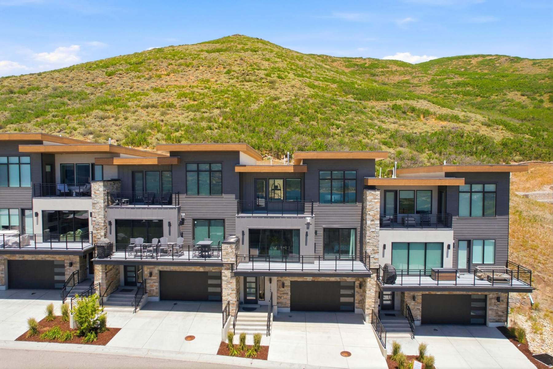 Enjoy sweeping panoramic views of the lake, mountains, and Deer Valley Resort  East Village from this beautifully appointed, fully furnished townhome at Klaim. Thoughtfully designed in a modern contemporary style, the residence showcases custom cabinetry, hardwood flooring, and quartz countertops throughout. Soaring ceilings-especially on the top level-create a bright, open atmosphere enhanced by expansive window packages that frame the surrounding scenery and flood the home with natural light. A dramatic three-panel sliding glass wall seamlessly blends indoor and outdoor living, bringing the views directly into the main living space.  The upper level features a secondary living area, ideal for relaxing, entertaining, or enjoying private time away from the main gathering spaces. The second level offers two additional bedrooms connected by a well-designed Jack-and-Jill bath, providing both comfort and functionality for family and guests.  Perfectly positioned at the top of the development and backing to 40 acres of dedicated open space, this property offers exceptional privacy and tranquility. The rear patio is perfectly suited for a hot tub, complemented by a convenient wet bar that enhances entertaining opportunities-whether indoors, on the patio, or from the upper balcony.  Ideally located just 15 minutes from Deer Valley Resort  East Village and minutes from Jordanelle Reservoir, you'll enjoy effortless access to boating, paddleboarding, hiking, biking, equestrian trails, and golf. Nightly rentals are permitted, offering excellent flexibility as a primary residence, vacation retreat, or investment property. Snow removal and landscape maintenance are included, creating a true lock-and-leave lifestyle opportunity.