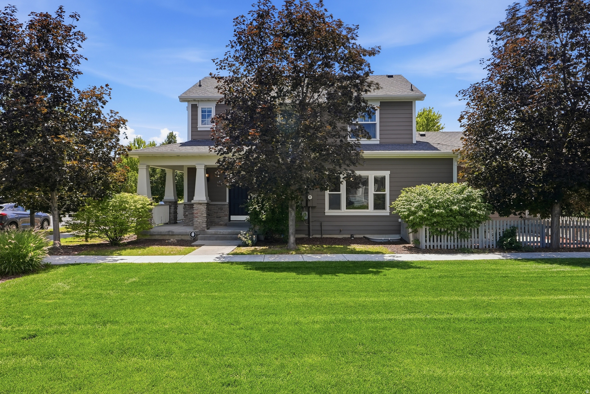 **OPEN HOUSE this SATURDAY 7/11 from 11AM-1PM** Charm, character, & an unbeatable location come together in this delightful Daybreak home! Nestled on a quiet, picturesque tree-lined street and perfectly situated next to beautiful common area green space, this home welcomes you with an inviting wraparound porch that sets the tone from the moment you arrive. Inside, you'll love the bright, open floor plan featuring soaring 9-foot ceilings that create a spacious & inviting atmosphere. The well-appointed kitchen is designed for both everyday living and entertaining, offering maple cabinetry, stainless steel appliances, a stylish tile backsplash, a center island w/ sink, & a refrigerator that's included w/ the home. The thoughtful layout continues upstairs w/ a spacious primary suite featuring a luxurious en-suite bathroom complete w/ double vanities, a separate soaking tub/ shower, & an enormous walk-in closet fit for a queen! A beautifully crafted staircase handrail adds warmth & elegance to the home's interior. The unfinished basement offers endless possibilities w/ stained concrete floors already in place, providing the perfect canvas for the new owner to create additional living space tailored to their needs. Additional features include a new AC (2 years old), water softener and a basketball hoop in the garage, adding convenience & fun to this already exceptional property. Located in the heart of Daybreak within walking distance to the lakes & schools, this charming home offers the perfect combination of comfort, functionality, and curb appeal- all just steps from green space & everything this vibrant community has to offer.