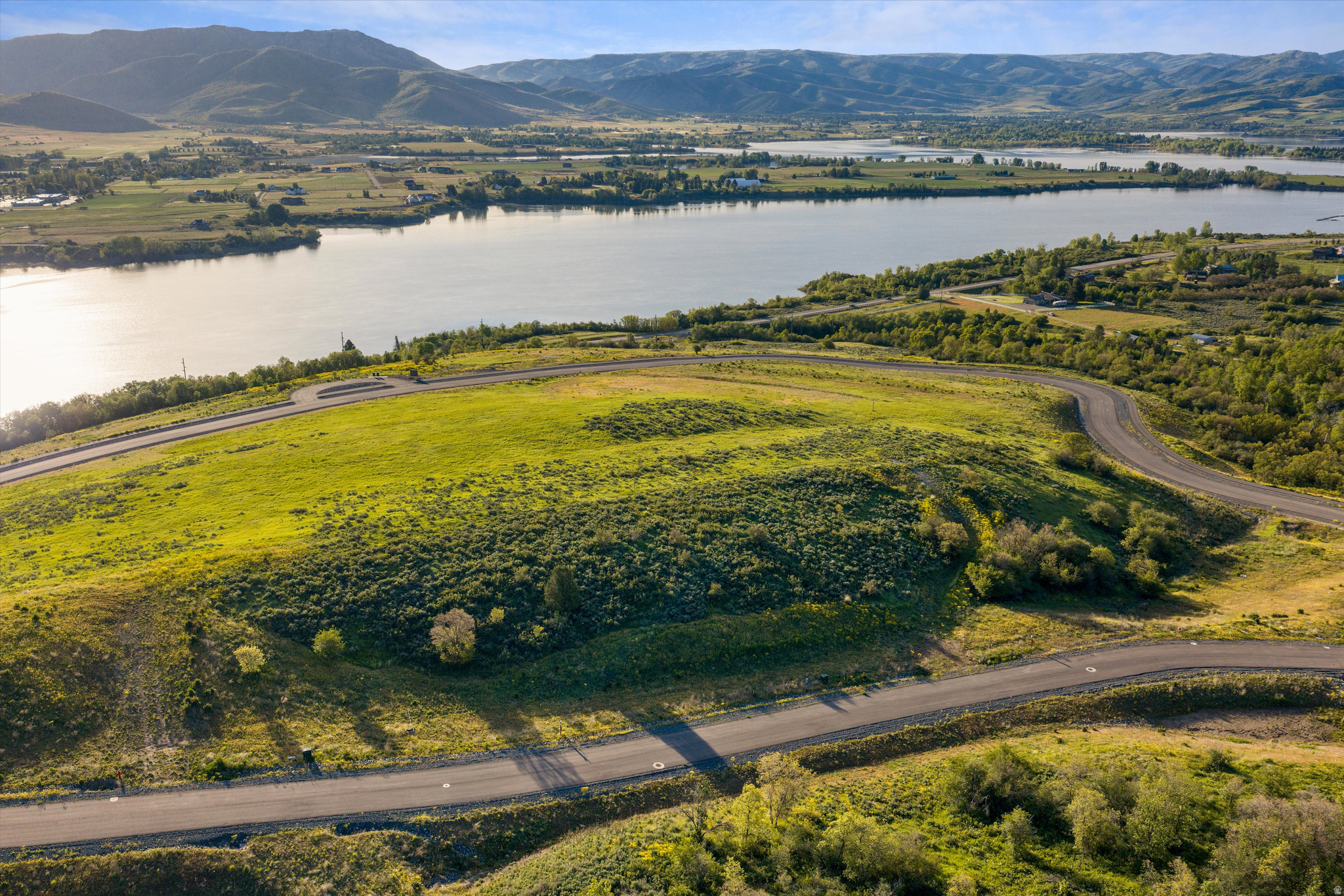 Osprey Ranch Lot 2 offers a rare opportunity to own a fully improved 5.06-acre ridgeline homesite with sweeping lake and mountain views, complete with water and sewer connections already in place. Positioned to capture panoramic vistas of Pineview Reservoir and the surrounding peaks, this expansive parcel provides both privacy and a striking setting for a custom legacy home designed for year-round indoor and outdoor living. Four-season recreation is right outside your door, from boating and beach days at Pineview to private Osprey Ranch trails for hiking and mountain biking. Winter brings easy access to the slopes at Powder Mountain, Snowbasin, and Nordic Valley. Lot 2 combines generous acreage, completed infrastructure, and remarkable lake views within one of Ogden Valley's most sought-after mountain communities. **Conceptual renderings shown are for illustrative purposes only; house plans are available upon request. Boundary lines are provided as a courtesy estimate only. Buyer is advised to obtain independent measurements.