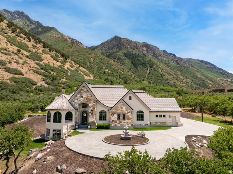 Stunning custom estate in Alpines highly coveted Willow Canyon Estates, offering unmatched 360-degree views of Lone Peak, Willow Canyon, and the surrounding Wasatch Mountains. Arrive via a 320-foot tree-lined driveway to a grand circle drive anchored by a stone fountain centerpiece  this exceptional masterpiece spans 6,922 square feet with 5 bedrooms, 4 bathrooms, two family rooms, a game room,  large den, and a lower level licensed ADU with it's own private entry, full kitchen, washer dryer, and walkout double doors .   The chefs kitchen has been thoughtfully updated with new quartzite countertops, custom cabinetry throughout , hickory hardwood floors, Wolf appliances, a built-in Sub-Zero refrigerator, Fisher & Paykel dish drawers, and a butlers pantry. The  dining area stuns with soaring vaulted ceilings, exposed wood beams, and a dramatic arched window framing unobstructed mountain views. Elegant arched doorways, art niches, and exceptional craftsmanship in the millwork and beams are found throughout.  The primary suite is a true sanctuary with a cozy fireplace, oversized windows overlooking lush mature trees, exceptional views of Bald  mountain and spa-inspired ensuite featuring dual sinks, a large jetted tub, walk-in shower, and travertine tile.   The lower level is approved for ADU rental with its own private driveway and double glass door entry.  Daylight walkout with unsurpassed views of Lonepeak. It features a complete kitchen with  granite countertops, rich cabinets, and built-in queen size  Murphy bed  for additional guests, and stone accents throughout.  The exterior was fully refreshed in 2025 with new stucco, fresh paint, new  lighting.  It has a well maintained  50-year bar tile roof. This home sits on a rare1.38 acre  parcel backing to BLM  land  and common area, offering complete privacy from your neighbors. The grounds feature a cascading water feature, gazebo, and 20 mature Colorado  Spruce. One block from Lambert Parks hiking and biking trails and just 15 minutes from American Fork Canyon and Uinta National Forest.  Welcome to life elevated