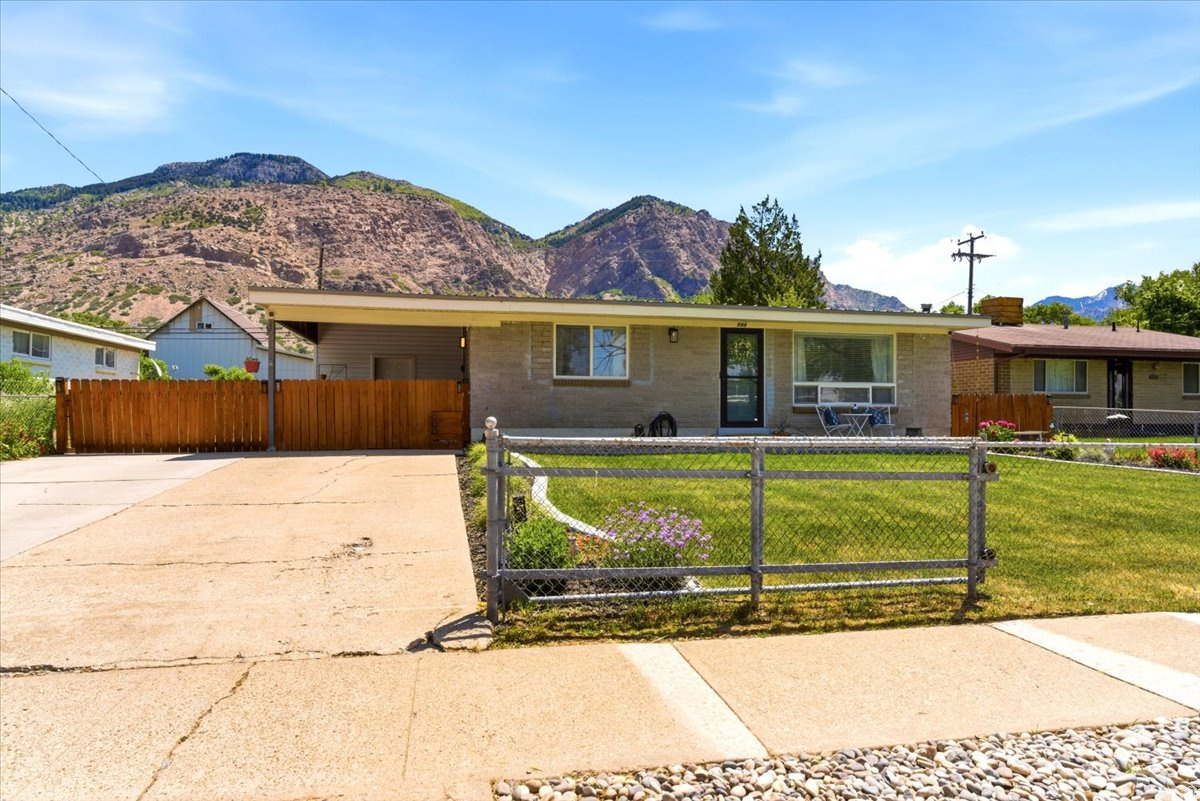 Charming and updated, this rare 4 bedroom rambler offers comfortable single level living in an established Ogden neighborhood with beautiful mountain views and a functional layout. The renovated kitchen (updated in 2021) features warm butcher block countertops, white shaker cabinets, SS appliances, a brand new gas range purchased just one month ago, built-in dishwasher, disposal, subway tile backsplash, brass hardware, and plenty of cabinet space. The home features hardwood, laminate, and tile flooring throughout, new central air and new furnace (2025), new water heater (2025), new double pane vinyl windows (2021), new paint (2021), and a newly added den/office/bedroom space off the main that includes a mini-split system with heating and cooling. The fully fenced 0.17 acre lot includes two patios, full landscaping, garden boxes, a lifetime metal roof that is only 10 years old, RV parking, covered carport parking, additional uncovered parking, and a 12'x18' storage shed for extra storage and functionality. With hard to find 4 bedroom space all on one level and tasteful updates throughout, this move in ready home offers comfort, practicality, and charm in a great Ogden location.