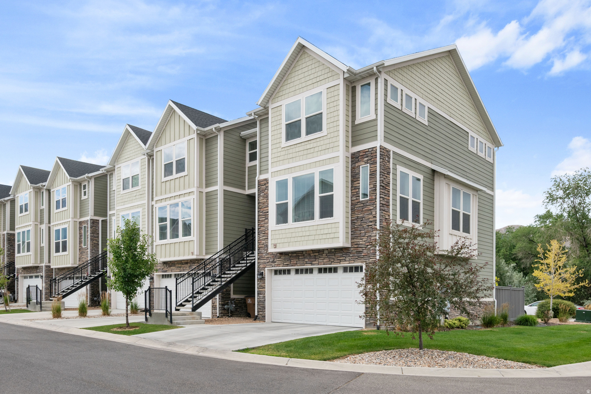 Discover elevated living in this beautiful, sun-drenched row-end townhome in Draper's coveted Creekside community-set along a picturesque creek with sweeping mountain and valley views. This prime location places you minutes from top-rated Canyons schools, shopping, dining, parks, and fast connections to I-15 and Bangerter, yet feels quietly tucked away.  Inside, a bright, open-concept main level welcomes you with expansive windows, airy volume, and seamless living-dining flow. The showpiece kitchen blends form and function with upgraded cabinetry, thick quartz countertops, a large single-basin sink, stainless steel appliances, gas range, and generous prep space. Step out to the private deck to savor tranquil water and hillside vistas-perfect for morning coffee or sunset gatherings.  Upstairs, the serene primary suite features a spacious bath and walk-in closet. A convenient hallway laundry and a second bedroom with its own ensuite bath create an ideal layout for privacy, guests, or a roommate. The daylight/walkout lower level adds a flexible third bedroom, full bath, and direct access to a fully fenced patio/yard-great for a play area, pet space, or an outdoor lounge. An extra-wide two-car garage with a dedicated storage nook keeps gear organized.  Thoughtful finishes include LVP, tile, plush carpet, double-pane windows, and central air with high-efficiency heating. Low-maintenance living is simplified by an HOA that covers water, trash, sewer, and snow removal, plus access to community picnic and playground spaces and nearby walking trails. With end-unit privacy, abundant natural light, and a smart three-level layout, this Creekside gem is equally built for everyday comfort and effortless entertaining. Tour it and feel the difference!