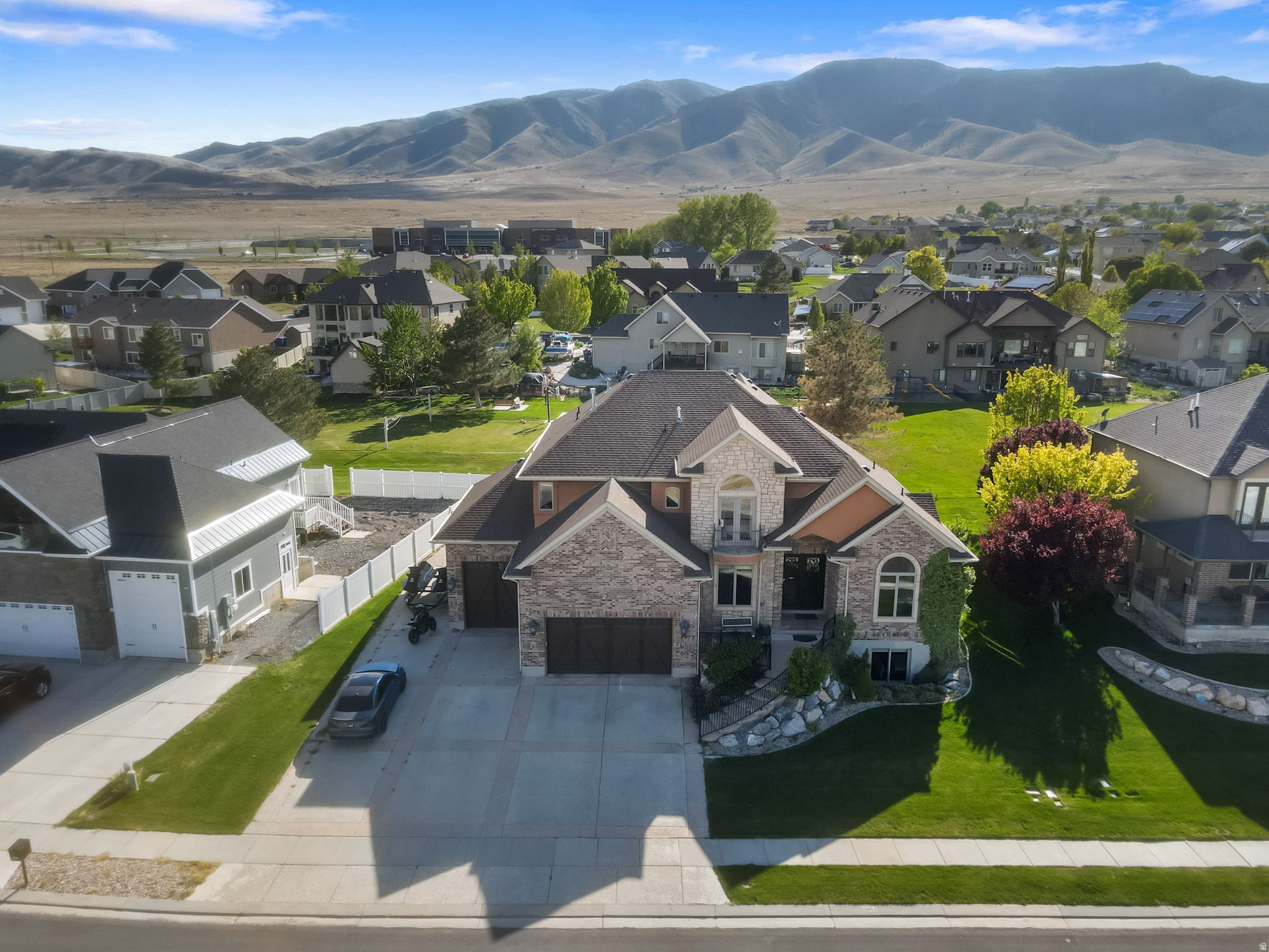 Wake up to sweeping lake and mountain views in this exceptional Saratoga Springs retreat, perfectly positioned near Utah Lake and just steps from the marina. Offering over 5,000 sq ft, this beautifully designed 6-bedroom, 4-bath home blends refined comfort, generous space, and serene waterfront living. Sunlight pours through expansive windows, illuminating the open-concept main level where the kitchen, dining, and great room flow effortlessly together-ideal for elegant gatherings or quiet evenings at home. The gourmet kitchen is a true centerpiece, featuring high-end appliances, an oversized built-in refrigerator, premium wood cabinetry, and a convenient pot filler-every detail thoughtfully curated to elevate daily living. The beautiful primary suite offers a private retreat, complete with its own fireplace, a walk-in closet with a view, and a spa-inspired bathroom featuring a relaxing jacuzzi tub. Upstairs, a built-in desk and bookshelves create the perfect space for work or study, while the basement features a dedicated home gym for added convenience and flexibility. Enjoy peaceful mornings and golden sunsets from the front porch, where panoramic lake and mountain views create a truly elevated everyday experience. Just beyond your kitchen door, an HOA-maintained sports court offers space to play and unwind, all without the upkeep! With RV parking and a versatile layout, this home seamlessly blends beauty, function, and location. Opportunities like this are rare-experience lakeside living at its finest in one of Saratoga Springs' most coveted settings.