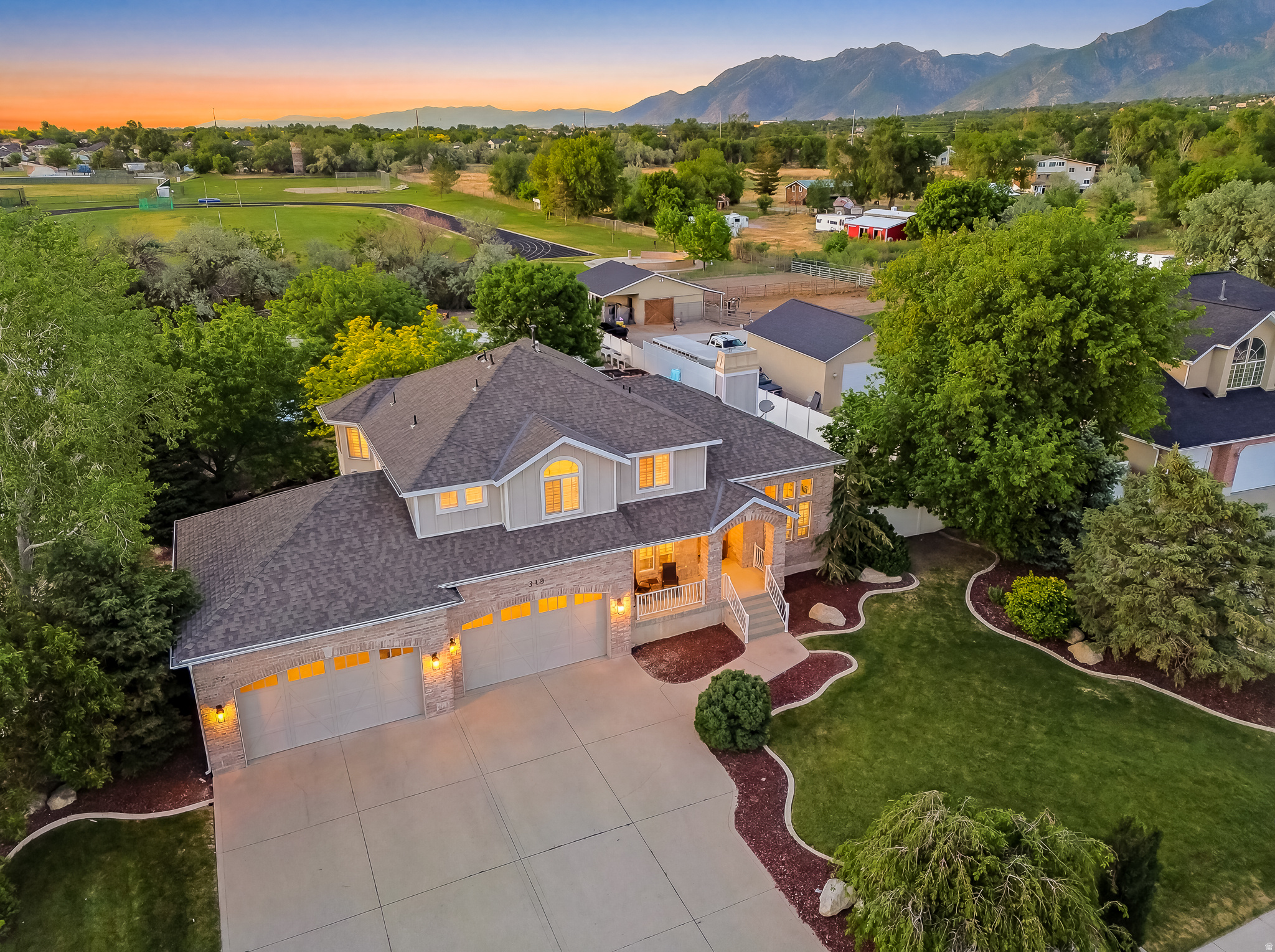 From the moment you arrive, it's clear this exceptional estate is something special. Situated on nearly one acre with breathtaking mountain views, this stunning two-story home offers the perfect blend of luxury, comfort, and resort-style living. A welcoming front porch leads to a grand entry featuring elegant marble flooring and rich hardwood floors throughout. The main level includes a formal living room, executive office or dining room, spacious family room with a fireplace, and a gourmet kitchen with premium appliances, custom cabinetry, marble countertops, and expansive windows overlooking the backyard oasis. The luxurious primary suite offers a spa-inspired bath with an oversized walk-in shower, soaking tub, large walk-in closet, and convenient in-suite laundry. Three additional bedrooms and a full bath complete the upper level. The walk-out lower level features a large gathering space with a fireplace, an additional bedroom, and a three-quarter bath, providing excellent space for entertaining or guests. BruteForce gym and shuffleboard table included. Smart-home technology allows convenient iPhone control of thermostats, lighting, door locks, and security cameras. A whole-home natural gas generator provides peace of mind during power outages and emergencies. The oversized four-car garage offers ample room for vehicles, storage, and recreational equipment. Outside, the resort-style backyard is truly spectacular, featuring a covered patio, outdoor kitchen with built-in BBQ, refrigerator, and sink, a sparkling in-ground pool with water slide, manicured lawns, custom playground, trampoline, water feature, fire pit, and raised garden beds. Even with its extensive amenities, the property offers abundant open space for horses, a detached shop, sports courts, additional garage space, or future expansion and a gate directly connected to Juan Diego School.  As an added benefit, a one-year home warranty is included, enhancing the comfort and confidence of ownership from day one. Combining luxury, privacy, smart-home convenience, stunning mountain views, and unmatched outdoor living, this one-of-a-kind property offers an extraordinary lifestyle opportunity. All information is deemed reliable but is not guaranteed and should be independently verified.