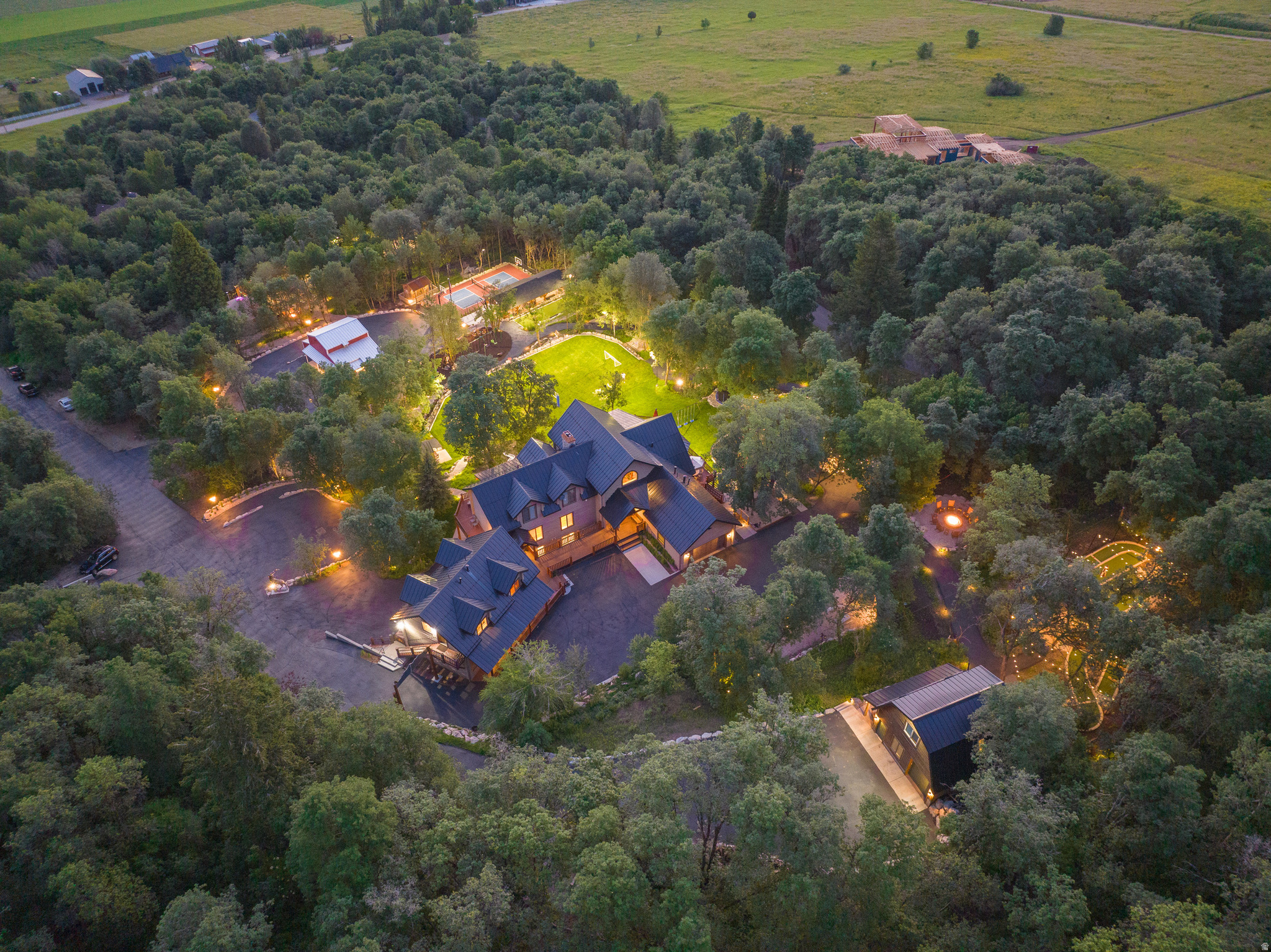 Forget the resort. Forget the hotel. This is something Ogden Valley has never seen before. Tucked away on approximately 3 private acres encompassed by Uintah-Wasatch-Cache National Forest in the heart of Liberty, this one-of-a-kind mountain escape was built with a singular vision: bring people together and never give them a reason to leave. Mission accomplished-and then some. There is room for everyone across a masterfully designed estate, this is not just a mountain property, it is a fully operational outdoor theme park, retreat, and family home wrapped in mountain magic. Whether you're hosting an extended family reunion, corporate retreat, multi-generational gathering, or building a legacy vacation home, nothing in Northern Utah comes close. The main cabin stands at an impressive 8,103 square feet and is purpose-built for large gatherings without sacrificing comfort. 12 bedrooms and 11 bathrooms give every generation their own space to retreat and recharge. This property offers a total of five distinct living spaces, making it truly unmatched in Northern Utah:  * Main Cabin  * Attached Guest Apartment  * Yurt  * Studio/Office * Apartment above garage.  Spread across six distinct activity levels, the property delivers an almost unbelievable list of amenities: A full-court basketball court, pickleball court, laser tag arena, paintball range, archery range, and hatchet throwing cage for the competitive crowd. A 9-hole dinosaur mini-golf course, adult and toddler zip lines, life-sized Connect Four, outdoor chess, disc golf course, bocce ball, and a sledding hill for the whole family. A jacuzzi spa, arcade, private theater, yurt, secret garden, and a "Find the Bigfoot" nature trail for those who want to slow down-just a little. A pavilion with outdoor kitchen, pizza oven, grills, and a barn with weight room, workshop, executive office, conference room, and guest apartment round out this extraordinary offering. Kayaks for the lake. Hammocks in the trees. A basalt fountain. Also includes photo opportunities with a moose, bear, and a wandering gnome. And if you ever do decide to venture out? Pineview Reservoir, three world-class ski resorts, North Fork hiking, mountain biking, a dinosaur park, a local shooting range, and the full amenities of Ogden City are all within 20 minutes. Properties like this don't come to market. They get passed down. Now it's your turn. All property information, boundaries and documents to be verified by buyer.
