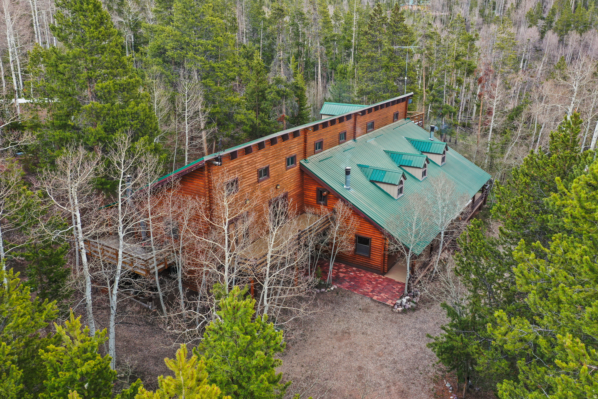 Opportunities like this don't come around often! This stunning mountain retreat is being offered at half of its appraised value!  This cabin has given its owners decades of cherished experiences, but it's now time to turn it over to a new family to begin making mountain memories. Nestled on 6.84 acres in the Manor Lands gated community, this property is perfectly designed for large family gatherings, group retreats, or corporate escapes. The cabin offers that perfect balance of large group areas and ample places to hide away and enjoy some me-time. The expansive living spaces include a large family room, an oversized kitchen, and a dedicated game room, while many of the 16 bedrooms walk out onto one of the multiple decks, making it convenient to step away and gather a sense of calm from the towering pines. With a seasonal share of the community water and two 1,000 gallon holding takes, the cabin has ample water year round. The best part, you can hop on your side-by-sides (which will be conveniently stored in the large garage) and, in mere minutes, access the miles of trails and endless recreation in the National Forest. This property is conveniently located near the winter parking, making winter access, via snow machine, a cinch.
