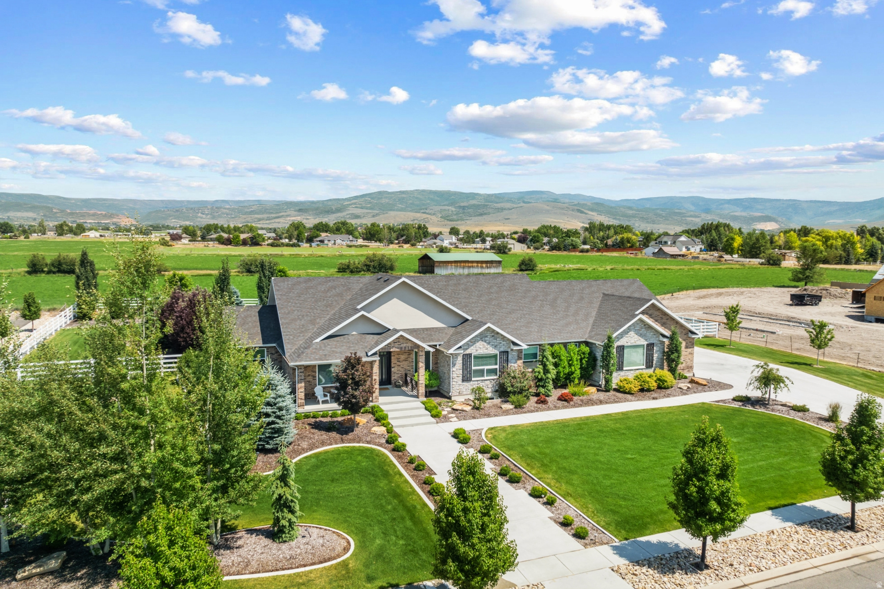 Luxury Custom Home in Summit Meadows | East Heber | 1 Acre Lot | Main-Level Living. Stunning custom luxury home located in the highly desirable Summit Meadows community in East Heber, set on a full 1-acre lot with breathtaking mountain and Timpanogos views. This beautifully designed brick residence combines elegance, functionality, and low-maintenance living with high-end finishes throughout. The home features a spacious open-concept floor plan with soaring ceilings, expansive windows, wood beam accents, and exceptional custom cabinetry. A striking custom metal entry door enhances both security and ventilation while setting the tone for the upscale design found throughout the home. The gourmet kitchen is built for entertaining and everyday luxury, featuring an oversized double stainless steel refrigerator/freezer, granite countertops, double wall ovens, two dishwashers, a gas range, and a hidden walk-in pantry. The kitchen flows seamlessly to a covered outdoor patio with a built-in gas BBQ area, perfect for enjoying panoramic mountain and backyard views. The main-level primary suite offers true comfort with two walk-in closets, a large soaking tub, a walk-in shower, and extensive custom cabinetry. The main floor also includes two additional bedrooms and bathrooms, providing true single-level living. The lower level expands the living space with four additional bedrooms, two bathrooms, a large family room, a media room, and a kitchenette. Two generous storage rooms provide ample additional space for organization and storage needs. Additional highlights include an oversized three-car garage suitable for large vehicles and recreational equipment, mature landscaping, and thoughtfully designed outdoor spaces that enhance privacy and curb appeal. There are also two-oversized water heaters with rapid recovery for all your hot water needs. Ideally located in the Heber Valley, this home is minutes from the upcoming Mayflower Mountain Resort, multiple world-class ski destinations, four public golf courses, the Provo River for fly fishing, and nearby reservoirs for boating and recreation. A rare opportunity to own a luxury estate in one of Heber's most sought-after communities.