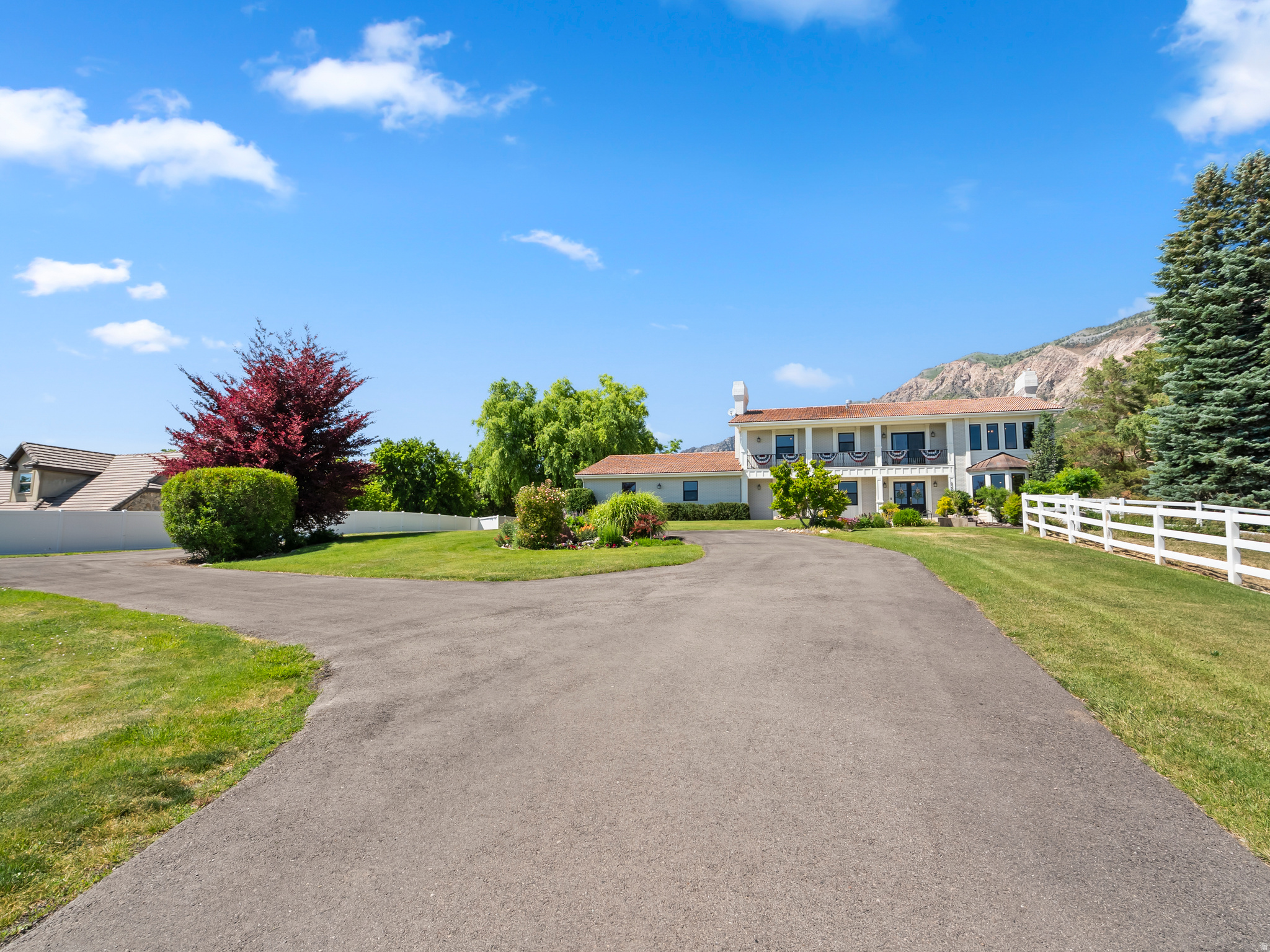 Extensively remodeled in 2021, this expansive 5,889-square-foot estate flawlessly combines luxury with functional acreage. The interior showcases elegant coffered ceilings, an expansive gourmet chef's kitchen, and a private main-level office complete with its own dedicated exterior entrance. Upstairs, the massive primary suite functions as a private retreat, featuring an integrated laundry area and windows framing beautiful valley views. The fully finished lower level offers a complete mother-in-law apartment (ADU) with its own kitchen, living space and private entrance which is perfect for guests or multi-generational living.  Outside, the two-acre property transitions from a white vinyl-fenced lawn into open pasture land fully permitted for horses and livestock. The entertainer's backyard features a large patio, mature trees, an 20x44 in-ground swimming pool, a hot tub, gas fire pit, a terraced garden, a custom dollhouse shed, and permanent holiday lighting, all set against a stunning mountain backdrop. Storage and utility are unmatched with a 4-car attached garage alongside a massive 30x70 detached workshop outbuilding equipped with three 11-foot doors.  Whether you're looking for a family estate, space for hobbies and recreation, or a home designed for entertaining, this home has it all.
