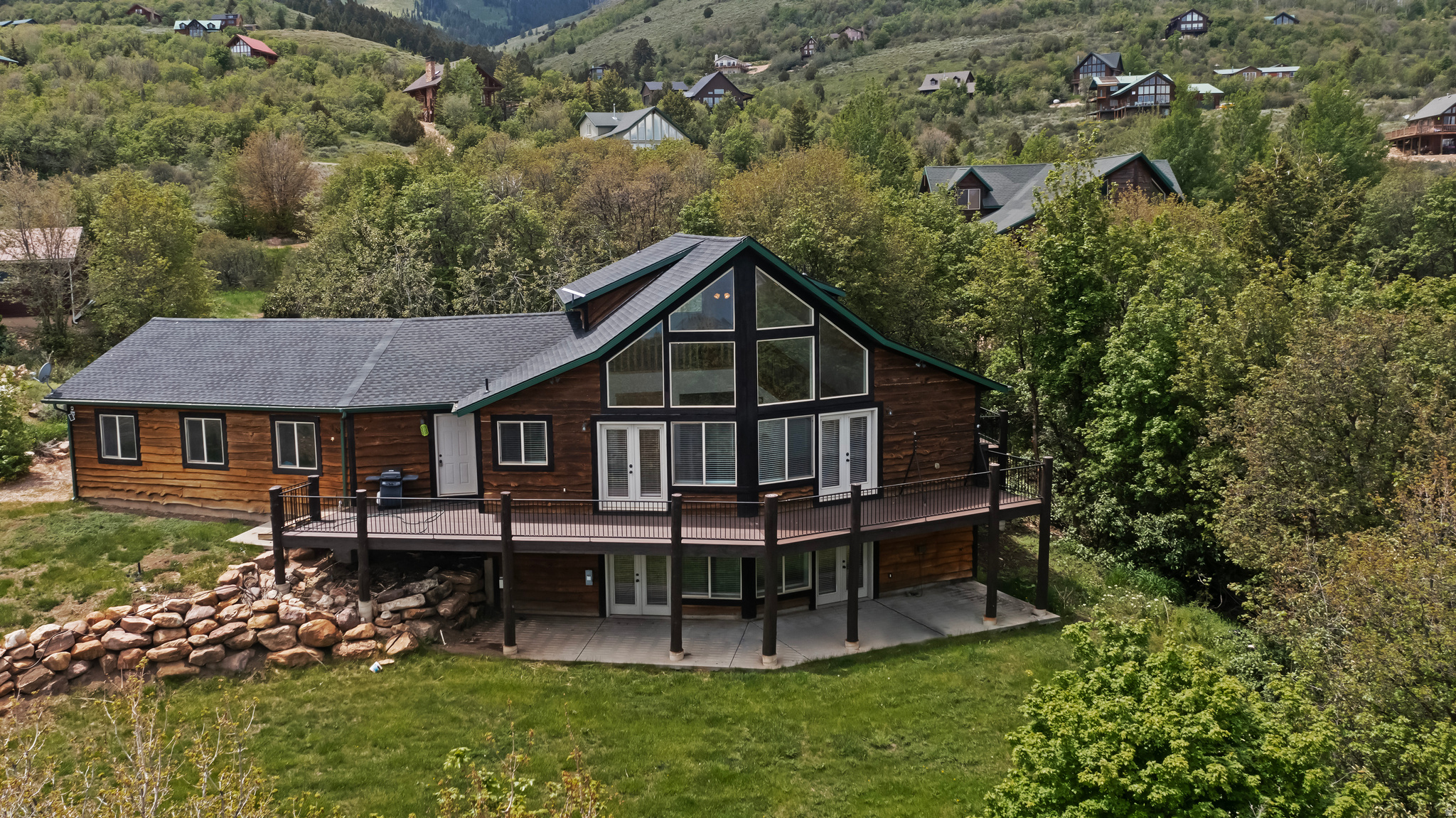 Nestled among the trees with beautiful views of Bear Lake and the surrounding mountains, this rustic three-level cabin offers the perfect blend of privacy, comfort, and mountain charm. Featuring 5 bedrooms and 4 bathrooms, the home showcases warm tongue-and-groove finishes, expansive view windows, granite countertops, stainless steel appliances, and knotty hickory cabinetry throughout. Two fireplaces create cozy gathering spaces, while three decks provide plenty of room to relax and enjoy the peaceful setting and scenic surroundings. An oversized garage offers ample space for vehicles, boats, and recreational toys. The cabin is being sold furnished, making it move-in ready for immediate enjoyment. Recent 2025 updates include a new roof, new premium Trex decking, new interior paint, new carpet, and freshly re-stained exterior trim, adding to the home's quality and appeal. Located in Bear Lake West, owners enjoy access to outstanding amenities including the Bear Lake West Golf Course, Cooper's Restaurant and Sports Bar with outdoor dining, a heated seasonal pool, indoor hot tub, tennis and pickleball courts, and gated beach access to Bear Lake. Bear Lake State Park Marina and downtown Garden City, with its shops, dining, and famous raspberry shakes, are just 10 minutes away, while Beaver Mountain Ski Resort is only 25 minutes from the property. Nightly rentals are not allowed, creating a quiet and relaxing retreat ideal for year-round enjoyment.
