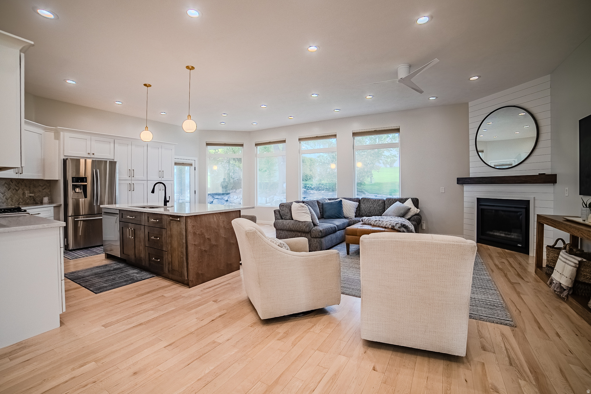 Rarely does a home offer this combination of privacy, flexibility, and convenience. Nestled in Riverton's coveted river-bottom corridor near the borders of South Jordan and Draper, this beautifully renovated custom home easily accesses the Jordan River Parkway and offers breathtaking views of the Wasatch Front and Lone Peak mountain range, all while remaining less than 10 minutes from Silicon Slopes, I-15, shopping, dining, and entertainment. Thoughtfully updated throughout, the nearly 4,900-square-foot floor plan features hardwood flooring, soaring ceilings, abundant natural light, and spacious gathering areas designed for both everyday living and entertaining. The chef's kitchen is the heart of the home, showcasing white shaker cabinetry, quartz countertops, premium stainless appliances, designer finishes, and an oversized island that flows seamlessly into the inviting great room. The sought-after main-floor primary suite provides a private retreat with direct backyard access and a spacious en suite bath. Downstairs, a fully equipped mother-in-law apartment offers exceptional flexibility with its own kitchen, living area, dining space, and private bedroom suite, making it ideal for multigenerational living, extended family, guests, or additional living space. Outside, enjoy a beautifully landscaped backyard with mature trees, expansive paver patios, covered outdoor living areas, and peaceful surroundings rarely found this close to everything. Located near the Jordan River Parkway Trail, Riverbend Golf Course, Riverton City Park, Loveland Living Planet Aquarium, Cowabunga Bay, and countless shopping and dining destinations, with world-class skiing, hiking, and recreation in Big and Little Cottonwood Canyons less than 30 minutes away. This is a rare opportunity to own a beautifully renovated custom home in one of the most desirable and connected locations along the Wasatch Front. Preferred lender incentive available. Contact Taylor for details.
