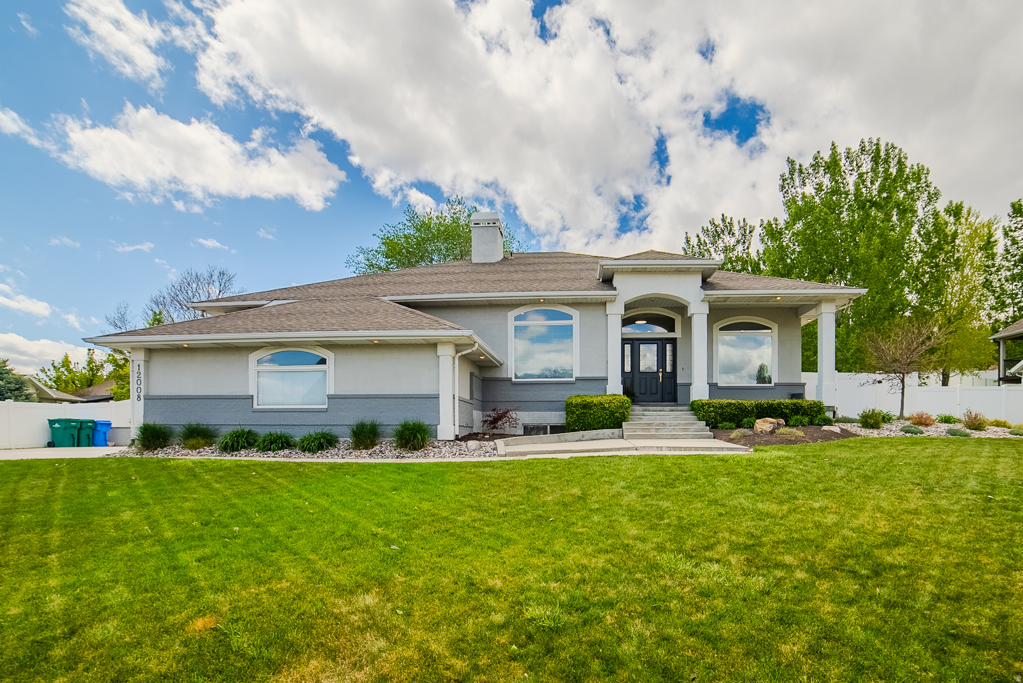 Tucked away in the serene river bottom at the coveted tri-border of Riverton, South Jordan, and Draper, 12008 Reeves Lane is one of those rare properties that simply has it all - and then some. This stunning east-facing custom home greets you every morning with breathtaking, unobstructed views of the Wasatch Front looking directly up at majestic Lone Peak, while direct access to the Jordan River Parkway sits right at your doorstep. Don't let the peaceful, tucked-away setting fool you - freeway access via 11400 South and 12600 South is just minutes away, and Silicon Slopes is less than a 10-minute drive, making this one of the most uniquely positioned homes on the market. From the moment you arrive, the custom craftsmanship is undeniable inside and out - spanning 4,890 square feet of thoughtfully renovated living space, the main level impresses with soaring 10-foot ceilings, beautiful hardwood floors, and a seamless open flow from the entry through the dining area into the stunning great room. The chef's kitchen is a showstopper with white shaker cabinetry, a herringbone tile backsplash, a generous quartz island, gold pendant lighting, and premium stainless appliances, all opening to the living room anchored by a shiplap fireplace with walnut mantle and a wall of oversized windows framing the lush backyard. The main-floor primary suite is a true sanctuary - a beautiful door opens to the backyard, and the spa-inspired en suite stuns with dual granite vanities, a floor-to-ceiling walk-in tile shower with glass enclosure, and a beautiful tray ceiling with arched detail. Downstairs, the fully self-contained mother-in-law apartment elevates this home to another level entirely, complete with its own full kitchen, stainless appliances, eat-in dining, and a spacious en suite bedroom with walk-in closet and dedicated sitting area - ideal for extended family, guests, or multigenerational living. Custom-built, beautifully renovated, and perfectly positioned in one of the most desirable and tranquil settings along the Wasatch Front - this is the one you've been waiting for. Don't miss it. Preferred Lender incentive reach out to Taylor for more information.