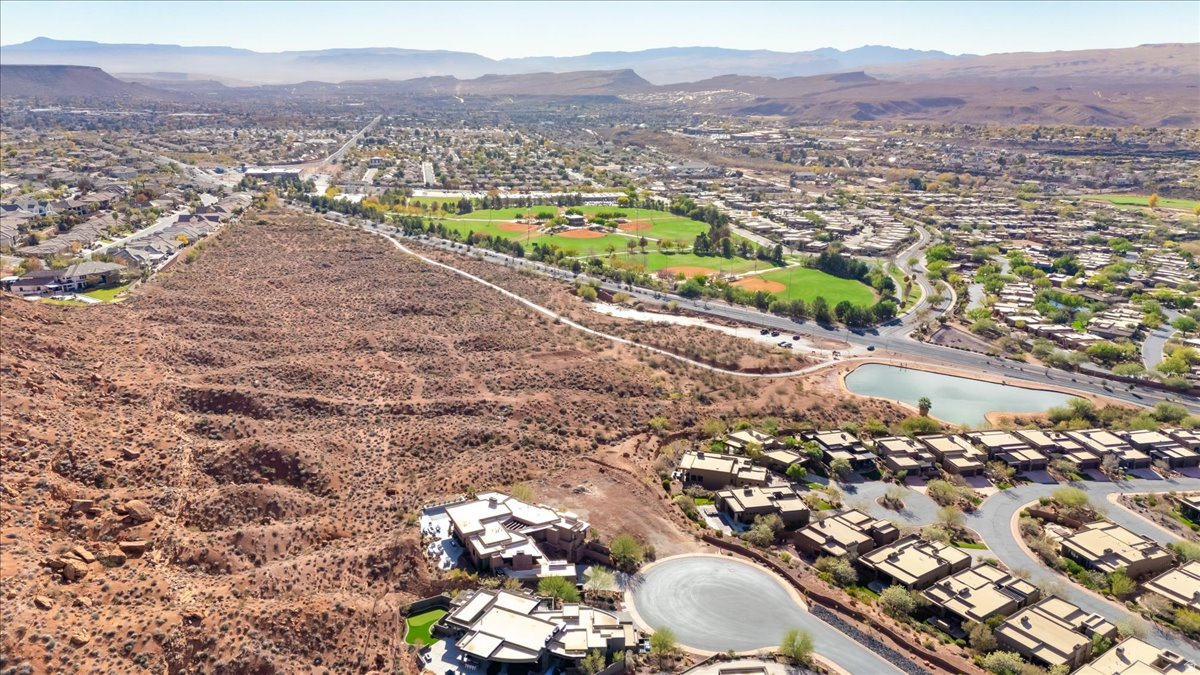 Set on a peaceful cul-de-sac in the prestigious Vistas at Entrada community, this exceptional .62 acre homesite offers the opportunity to create a truly remarkable custom residence surrounded by some of Southern Utah's most breathtaking scenery. Elevated above the neighboring rooftops, the property captures sweeping 270 degree panoramic views of Snow Canyon, Red Mountain, layered desert mesas, and the sparkling city lights of St. George stretching across the valley below.  The lot's generous size and natural topography provide the perfect foundation for a luxury architectural masterpiece designed to maximize indoor outdoor living, expansive walls of glass, and beautifully integrated outdoor spaces. Backing to a protected tortoise reserve, the homesite offers rare privacy and the assurance of no future development directly behind you.  Surrounded by stunning modern estates, this setting delivers a dramatic yet peaceful atmosphere with ever changing desert skies, glowing sunsets, and unforgettable twilight views. Located within the sought after Entrada at Snow Canyon community, residents enjoy access to world class amenities including championship golf, pickleball, tennis, resort style pools, fitness facilities, dining, and miles of scenic walking and biking trails, all moments from Snow Canyon State Park.  As one of the final remaining homesites in this coveted luxury enclave, this is a rare opportunity to build a legacy property in one of St. George's most exclusive communities.